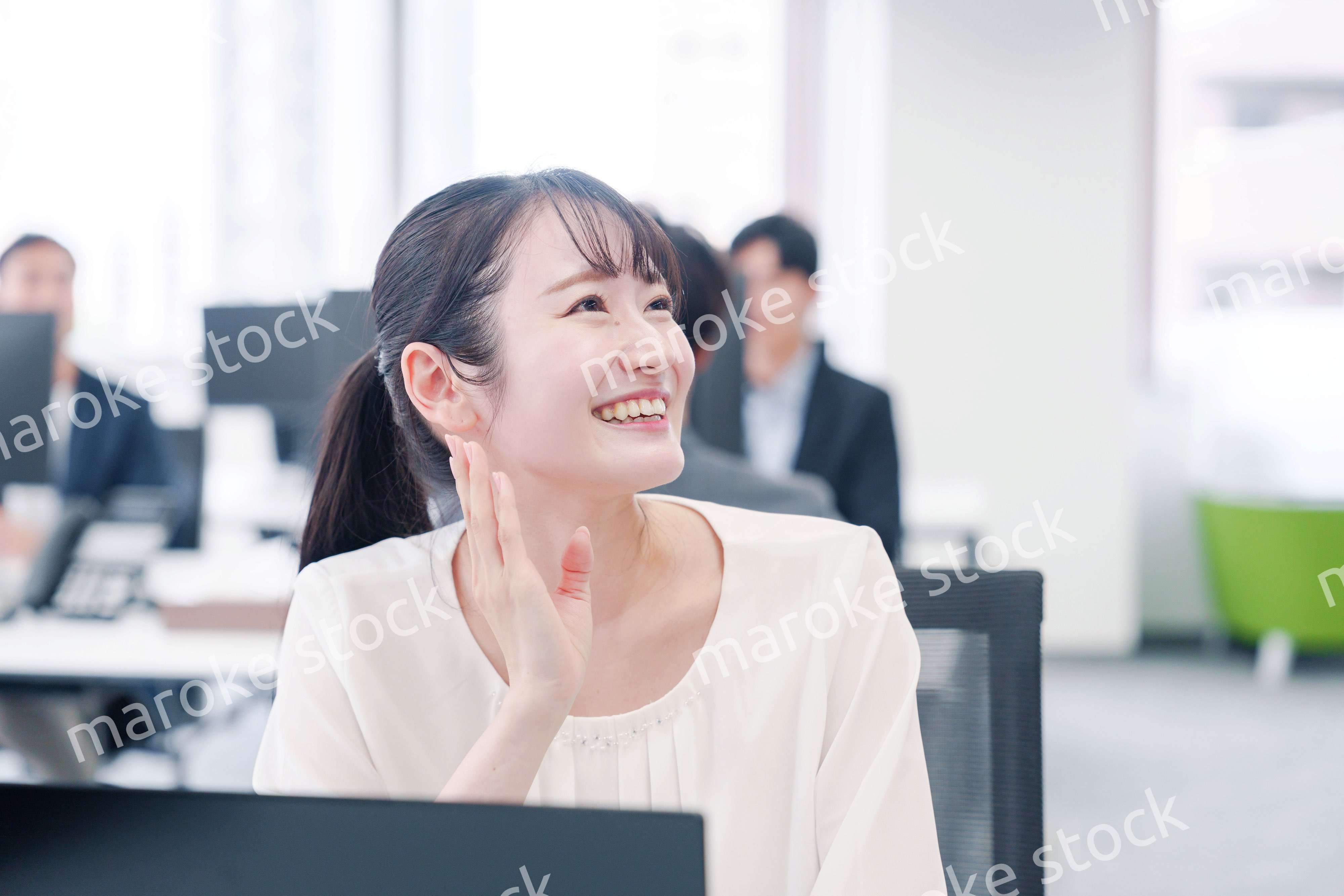 オフィスで楽しく雑談をする若い女性