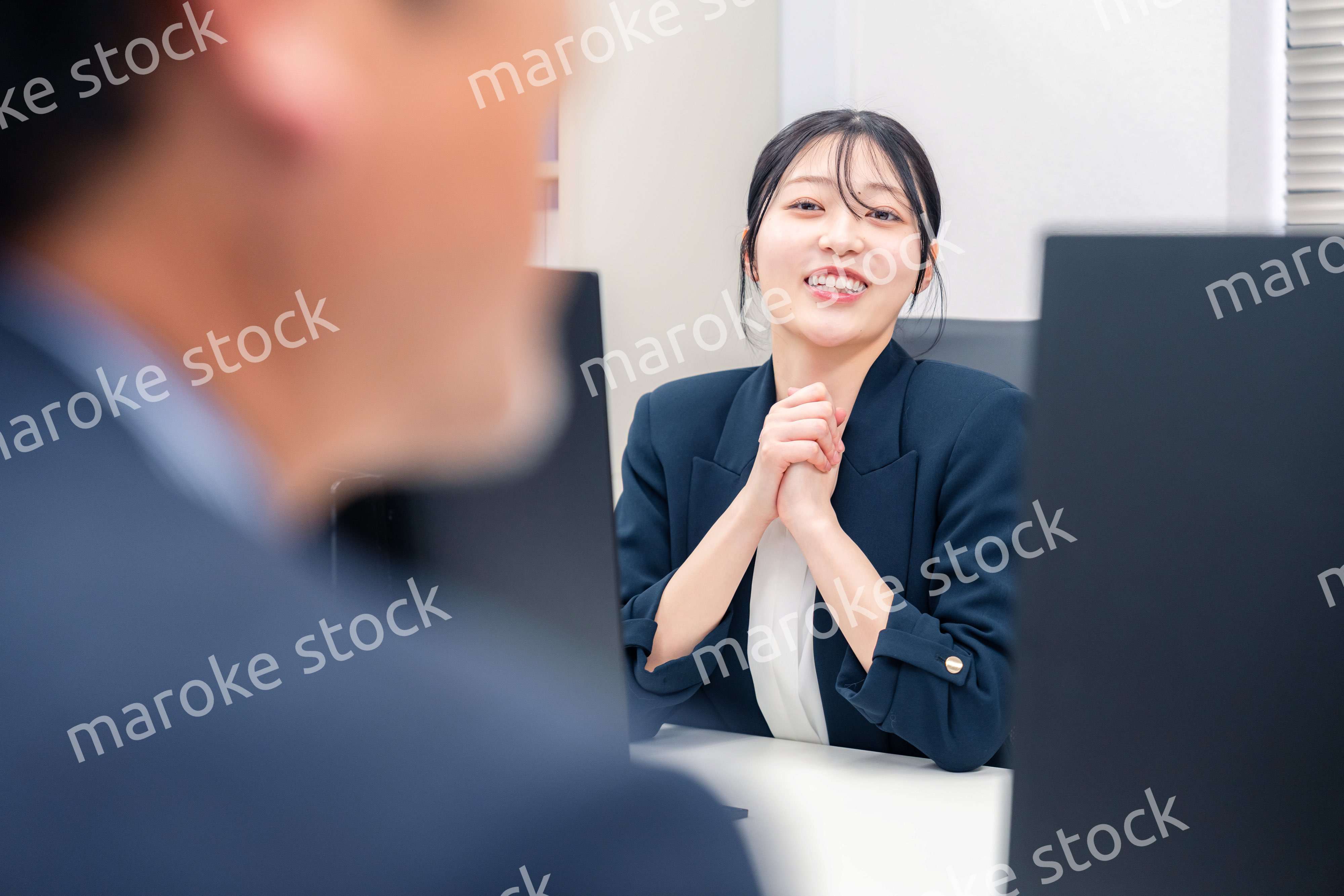 オフィスで生き生きとデスクワークをする若い女性