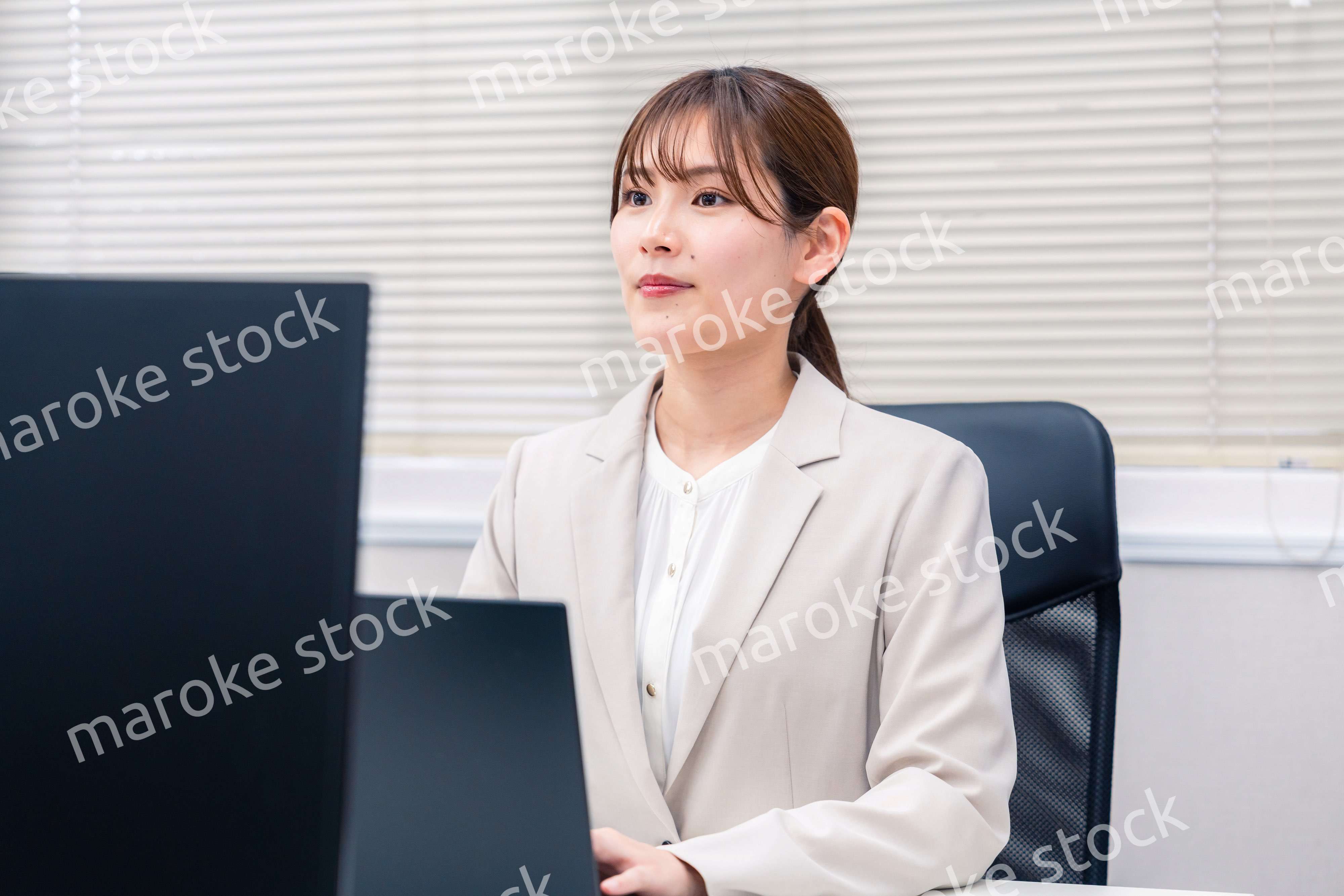 役所でデスクワークをする公務員の若い女性