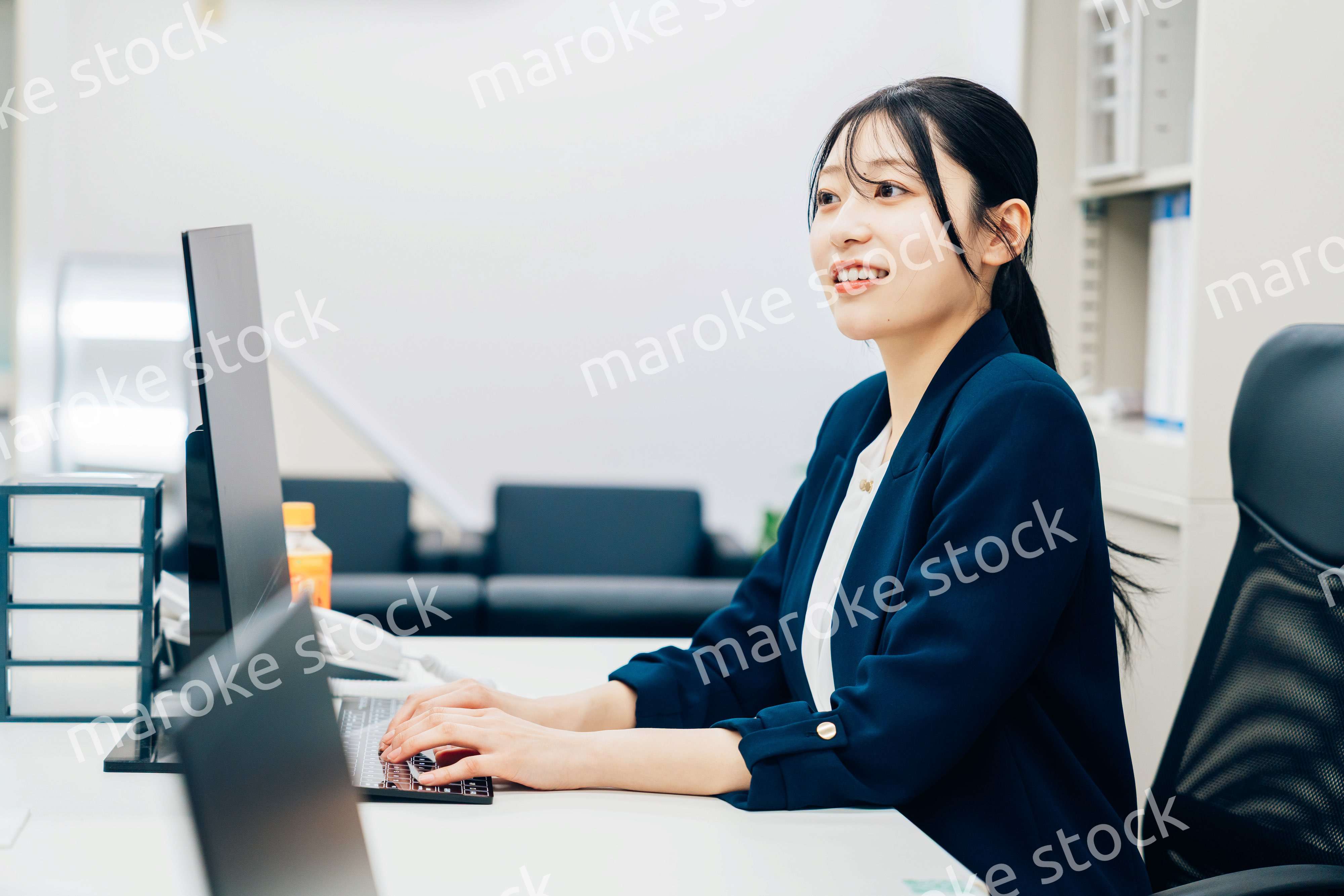 オフィスカジュアルで仕事をする若い女性