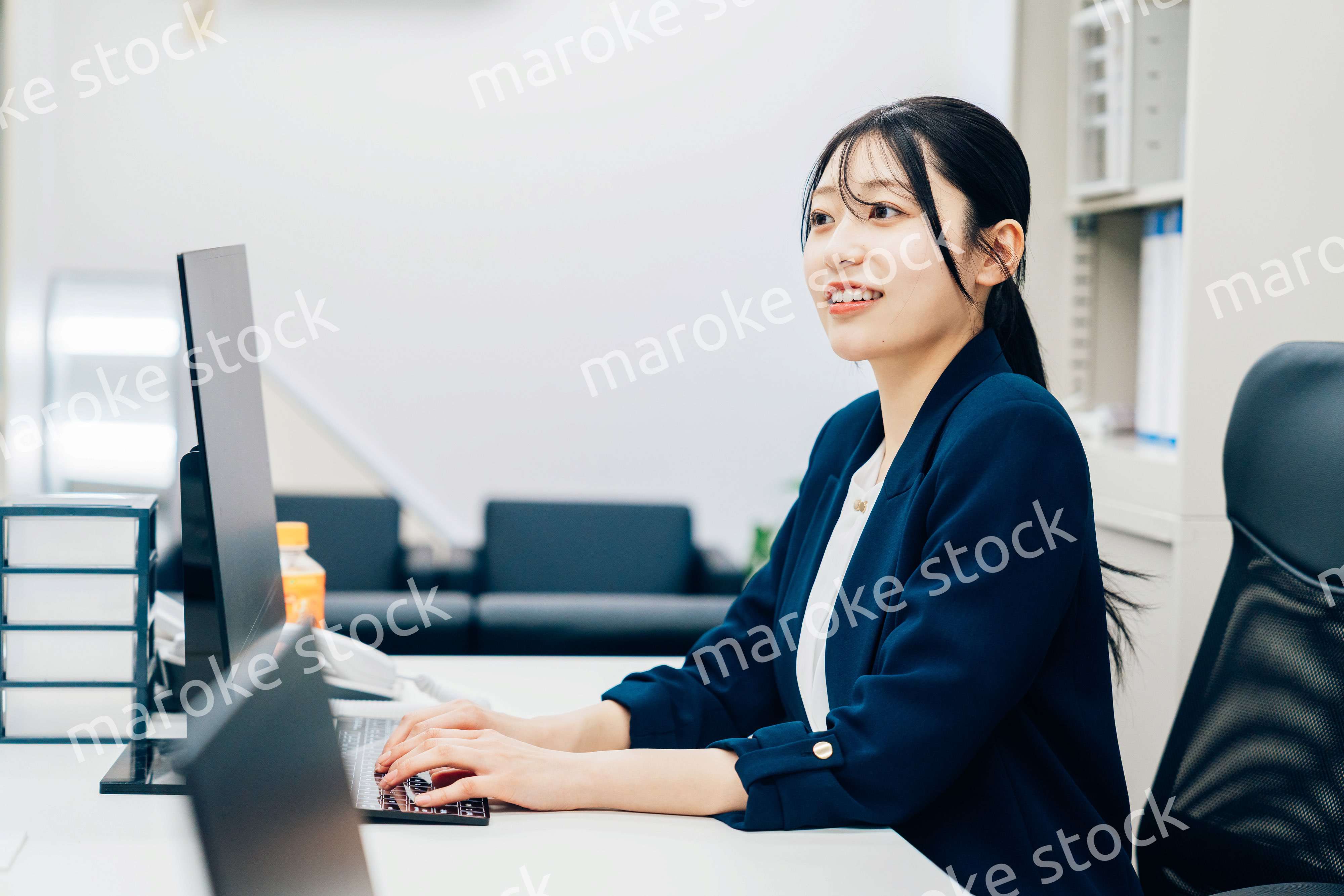 オフィスカジュアルで仕事をする若い女性