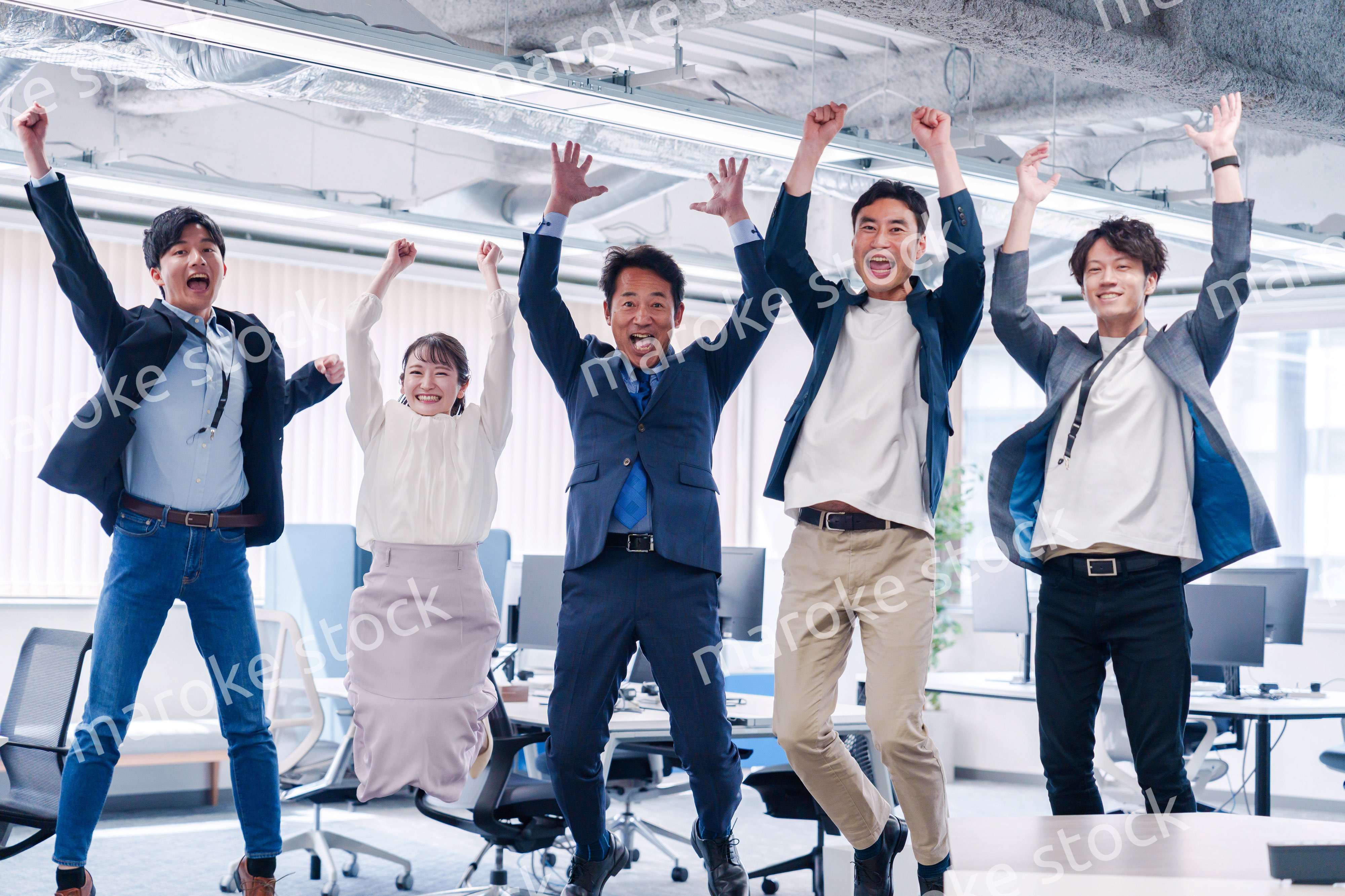 オフィスで大喜びをしてジャンプをするビジネスパーソン