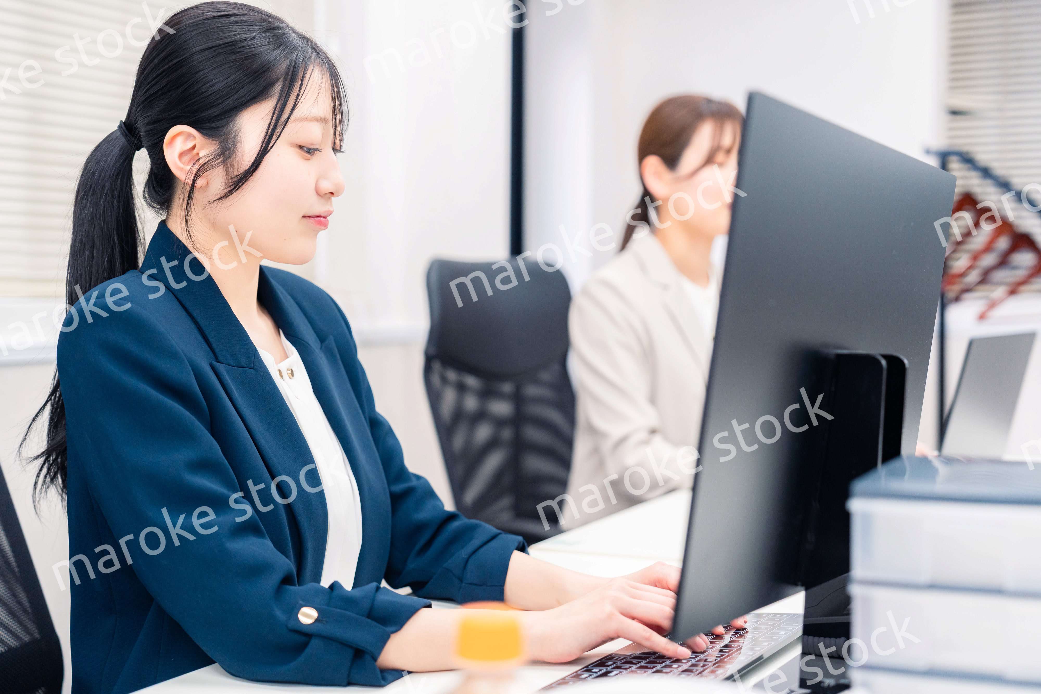 オフィスでデスクワークをする若い女性