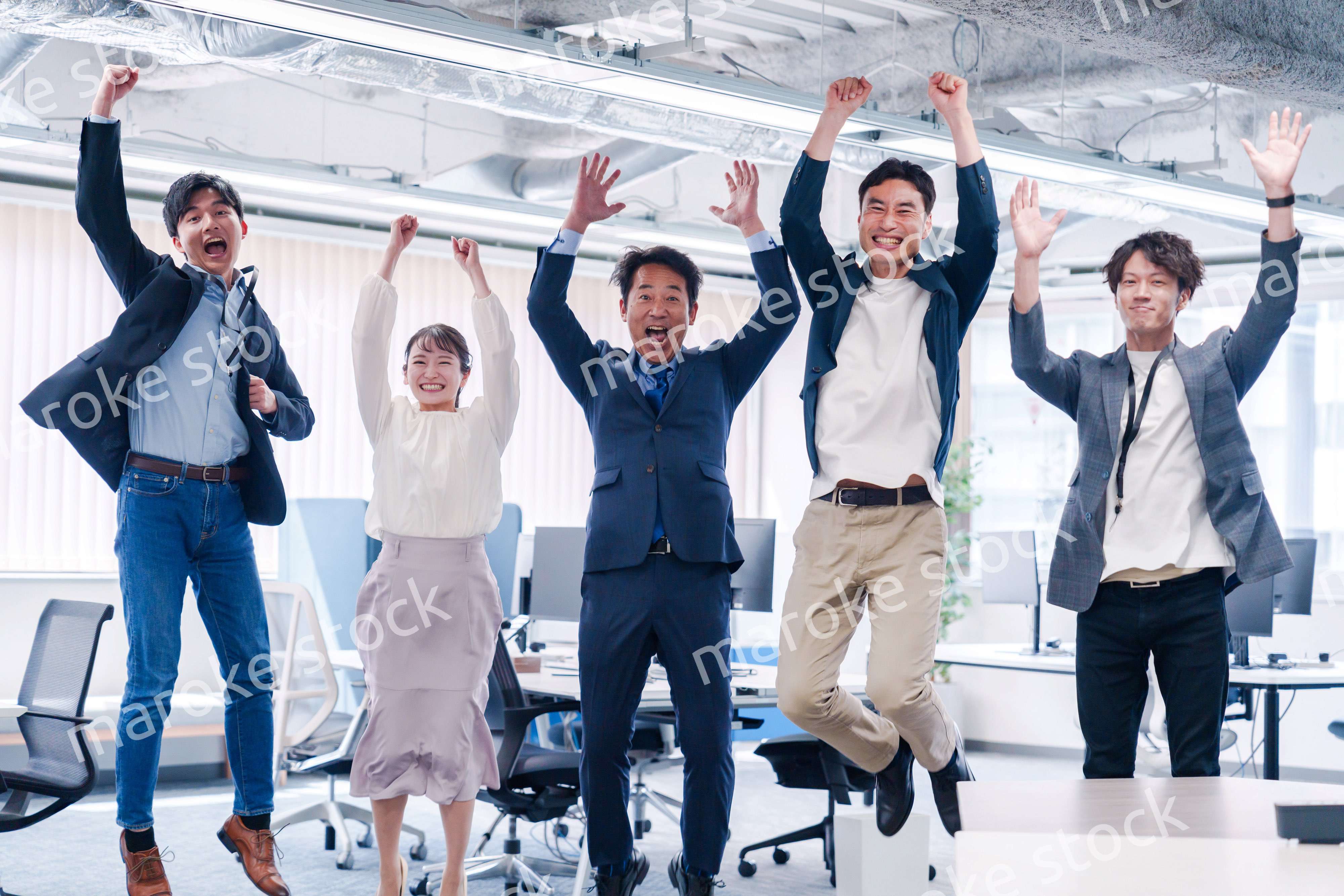 オフィスで大喜びをしてジャンプをするビジネスパーソン