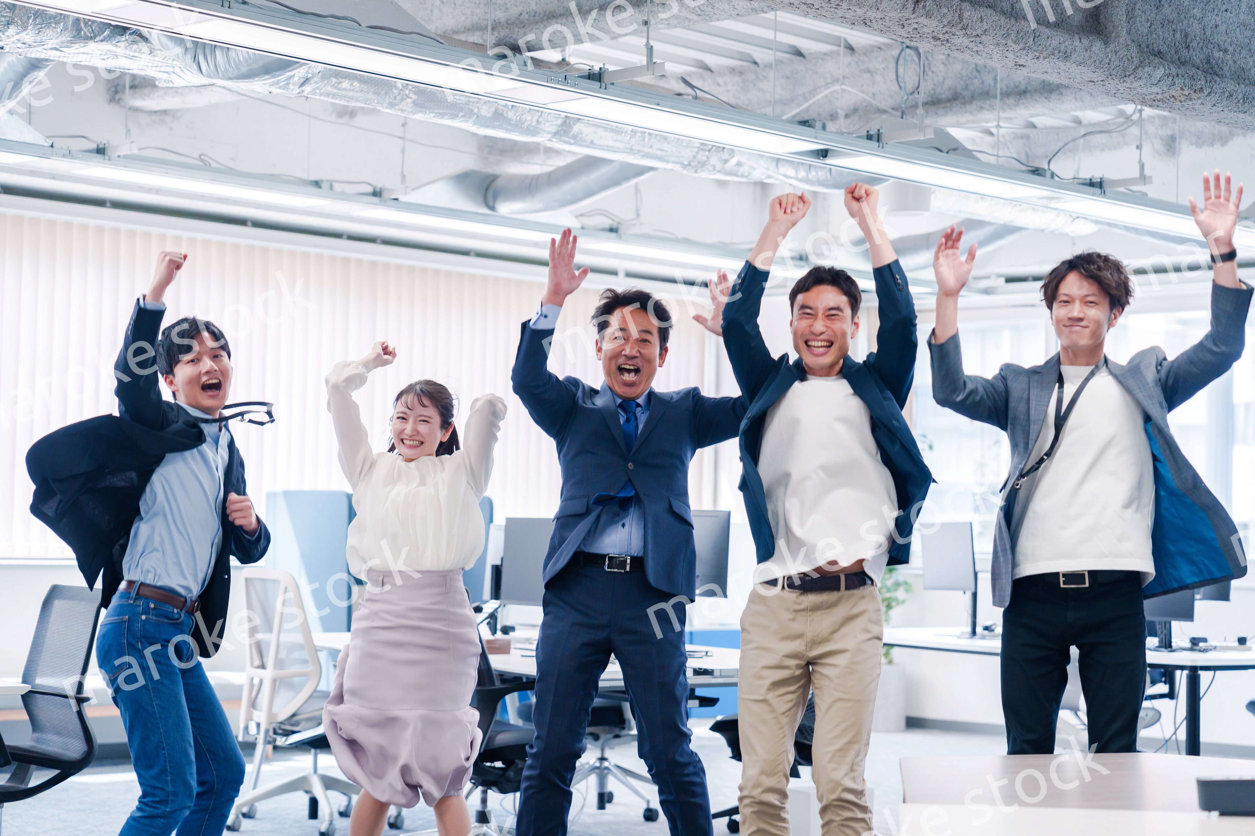 オフィスで大喜びをしてジャンプをするビジネスパーソン