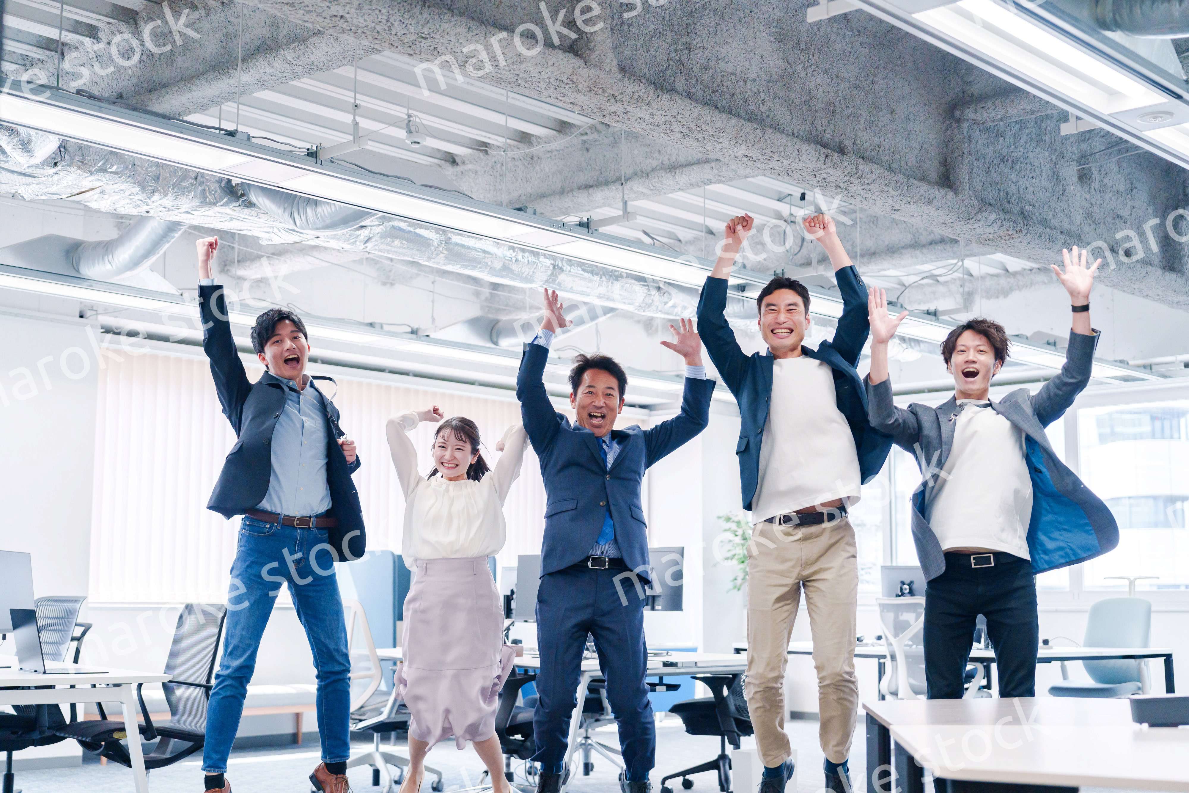 オフィスで大喜びをしてジャンプをするビジネスパーソン