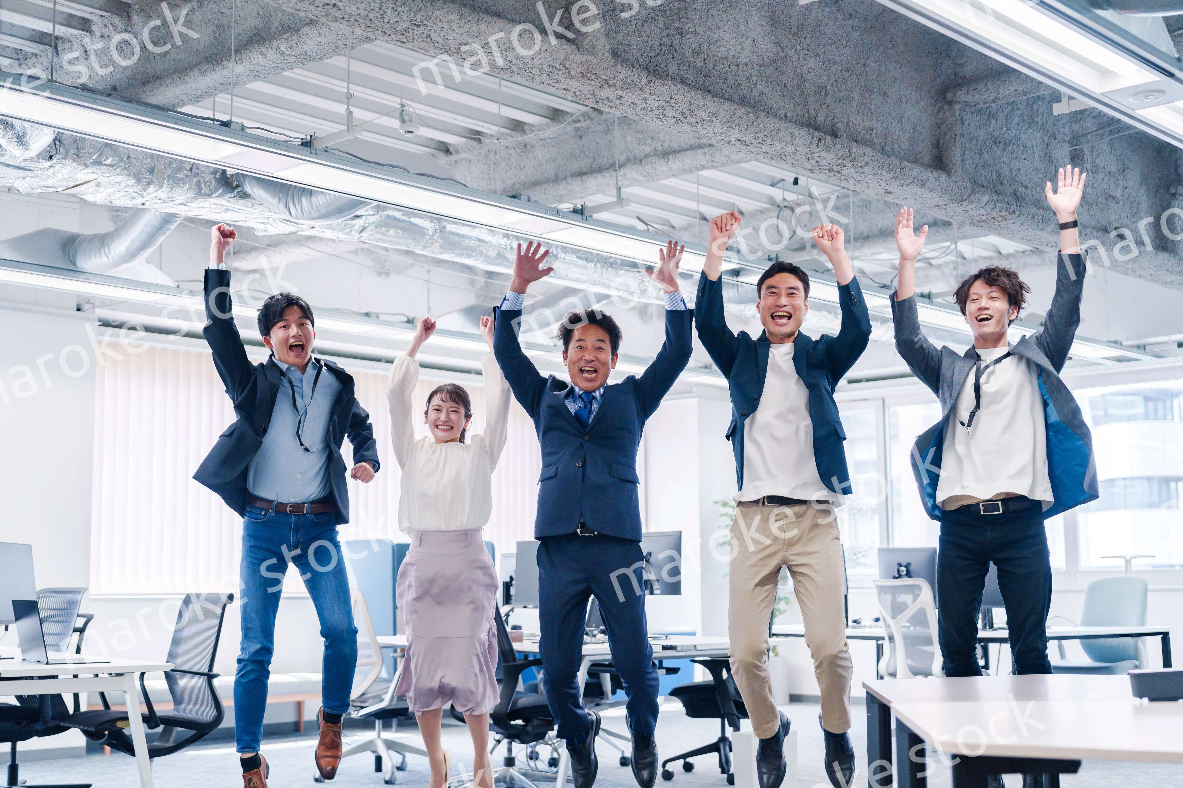オフィスで大喜びをしてジャンプをするビジネスパーソン