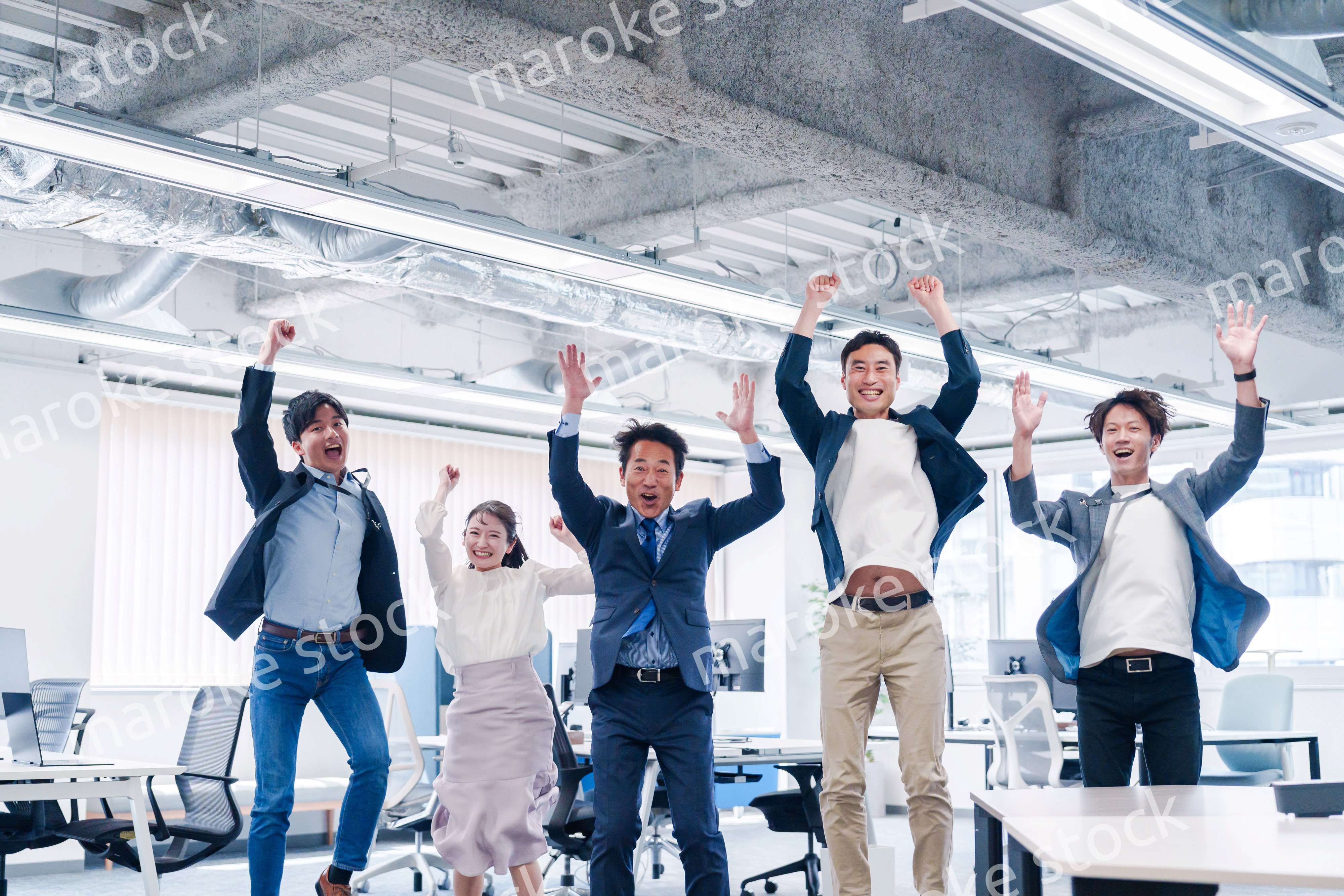 オフィスで大喜びをしてジャンプをするビジネスパーソン