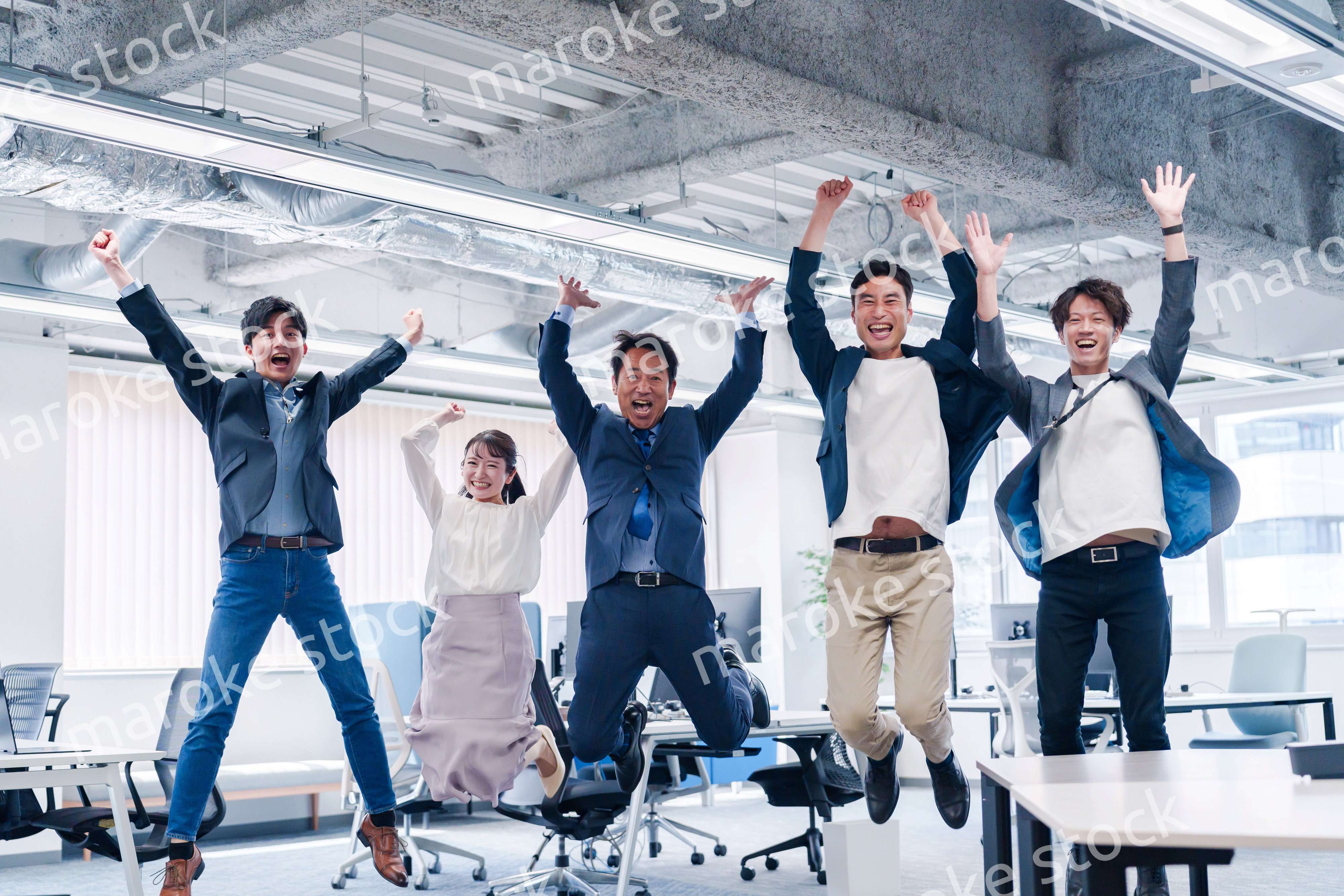 オフィスで大喜びをしてジャンプをするビジネスパーソン