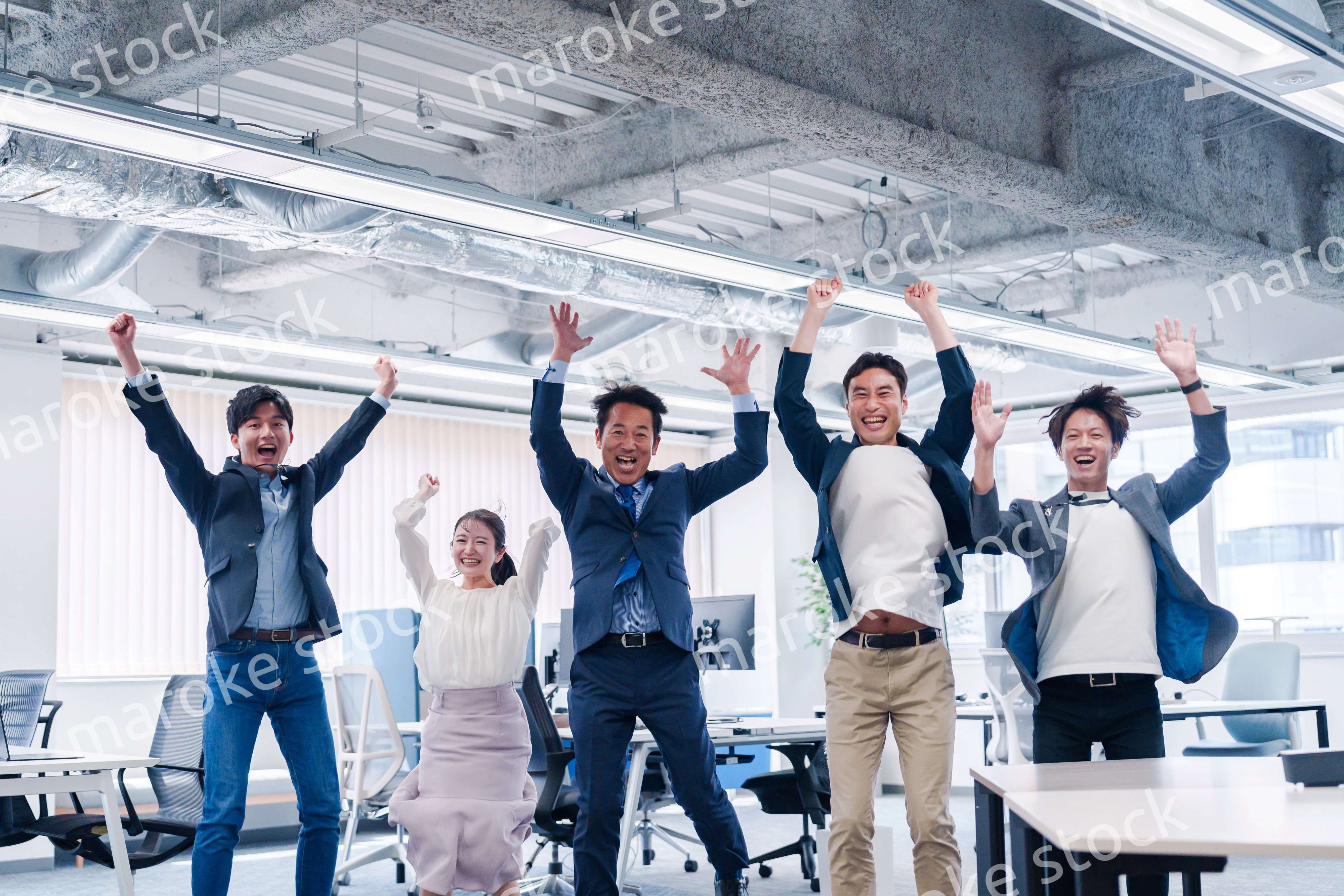オフィスで大喜びをしてジャンプをするビジネスパーソン