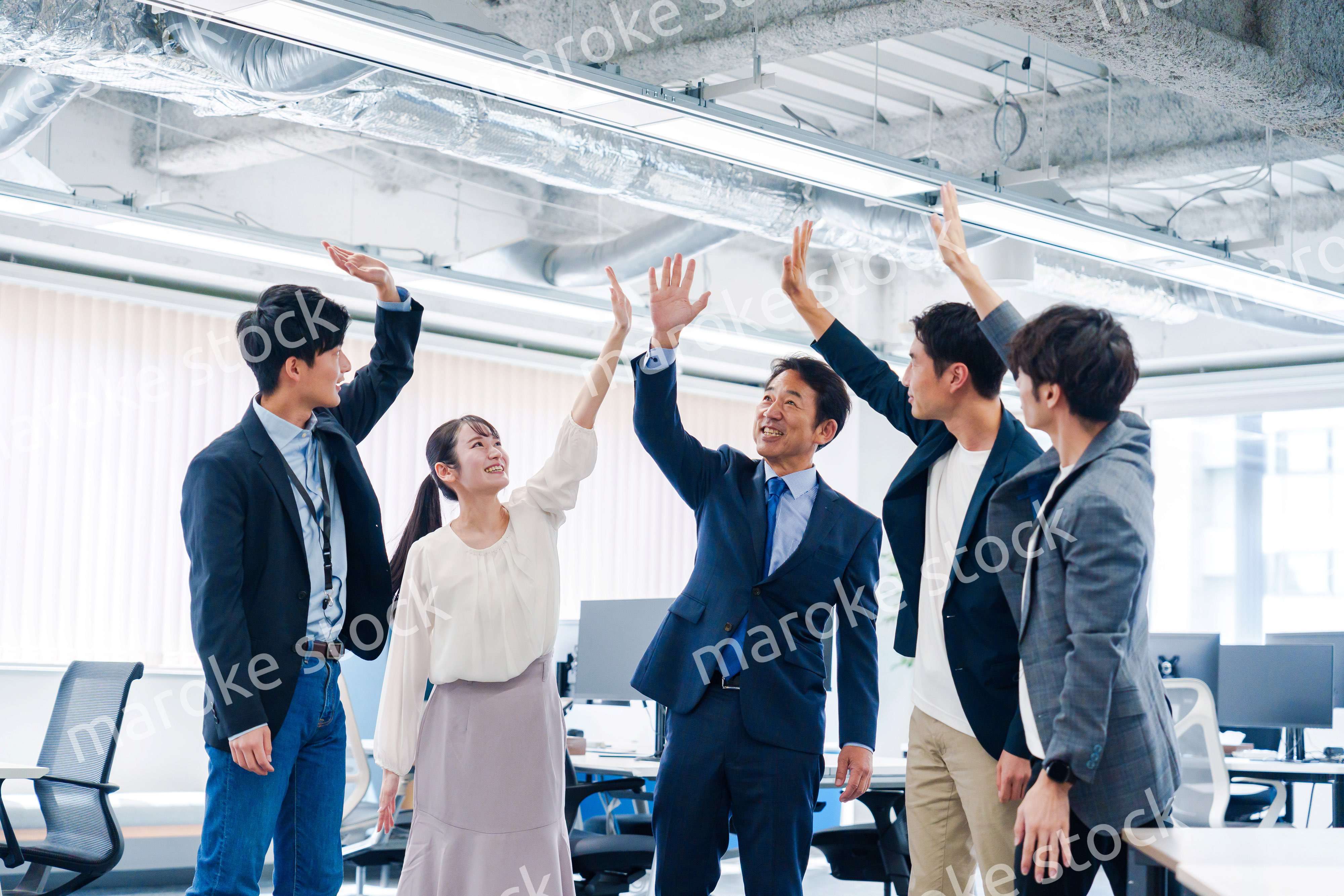 オフィスでハイタッチをするビジネスパーソン