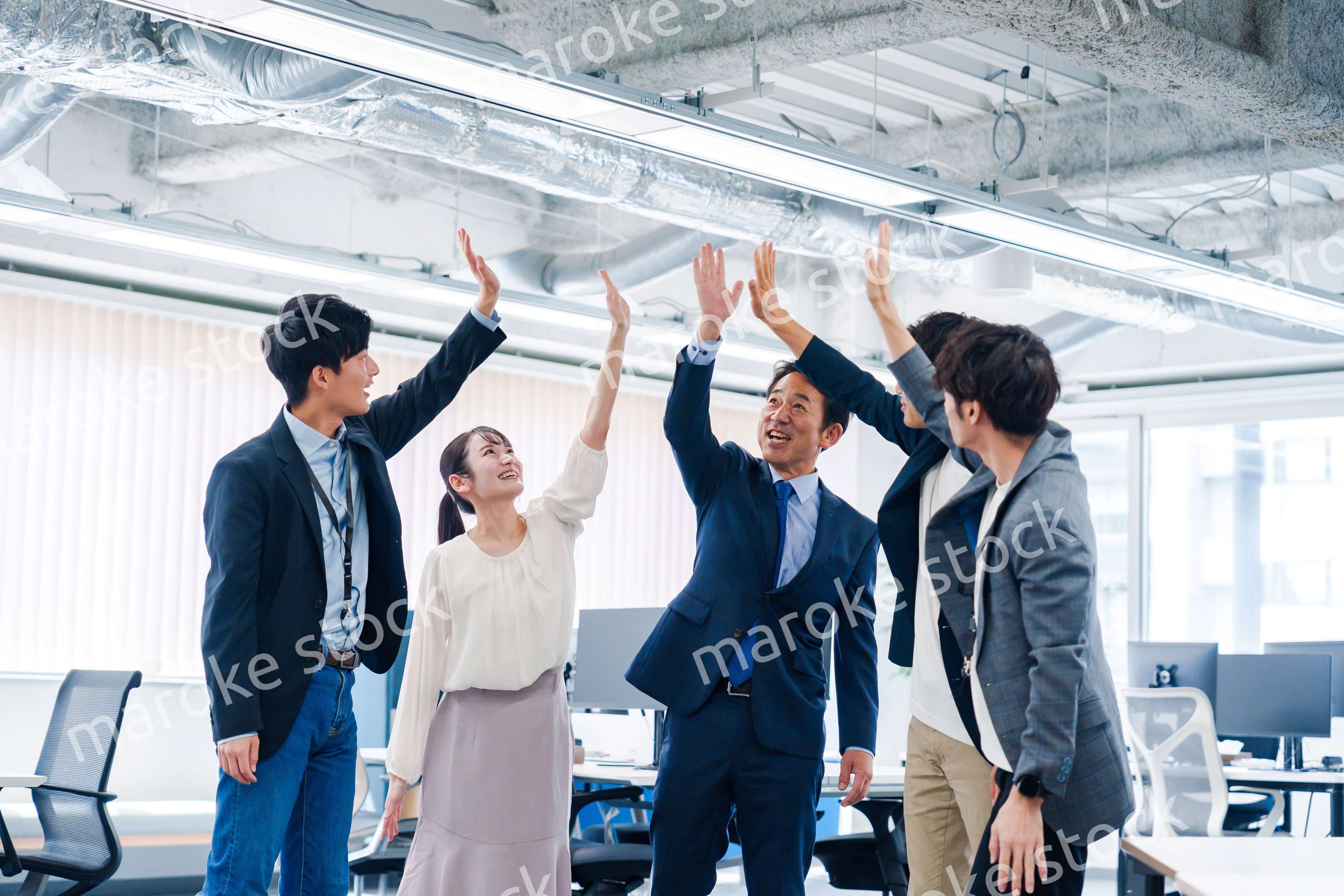 オフィスでハイタッチをするビジネスパーソン