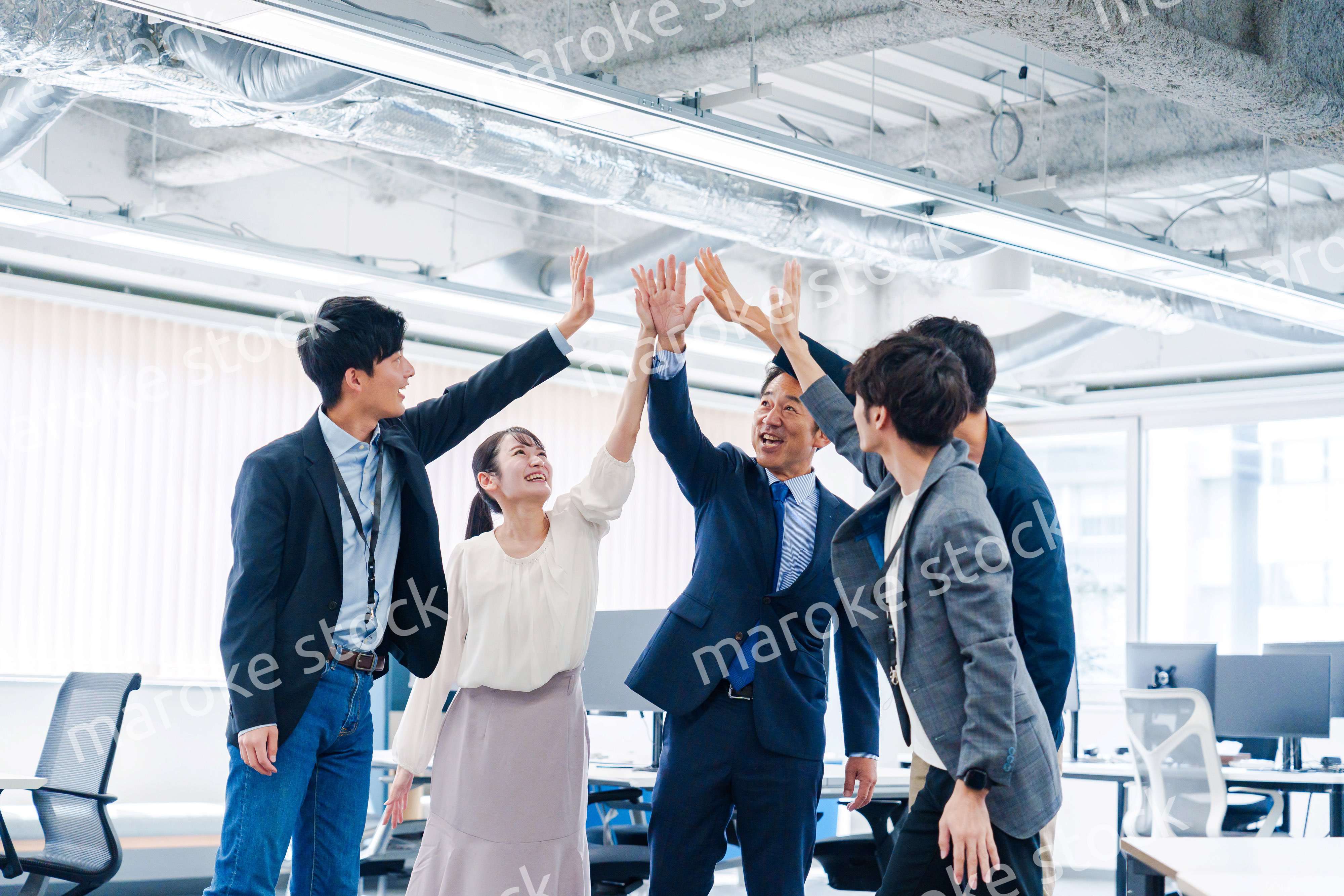 オフィスでハイタッチをするビジネスパーソン