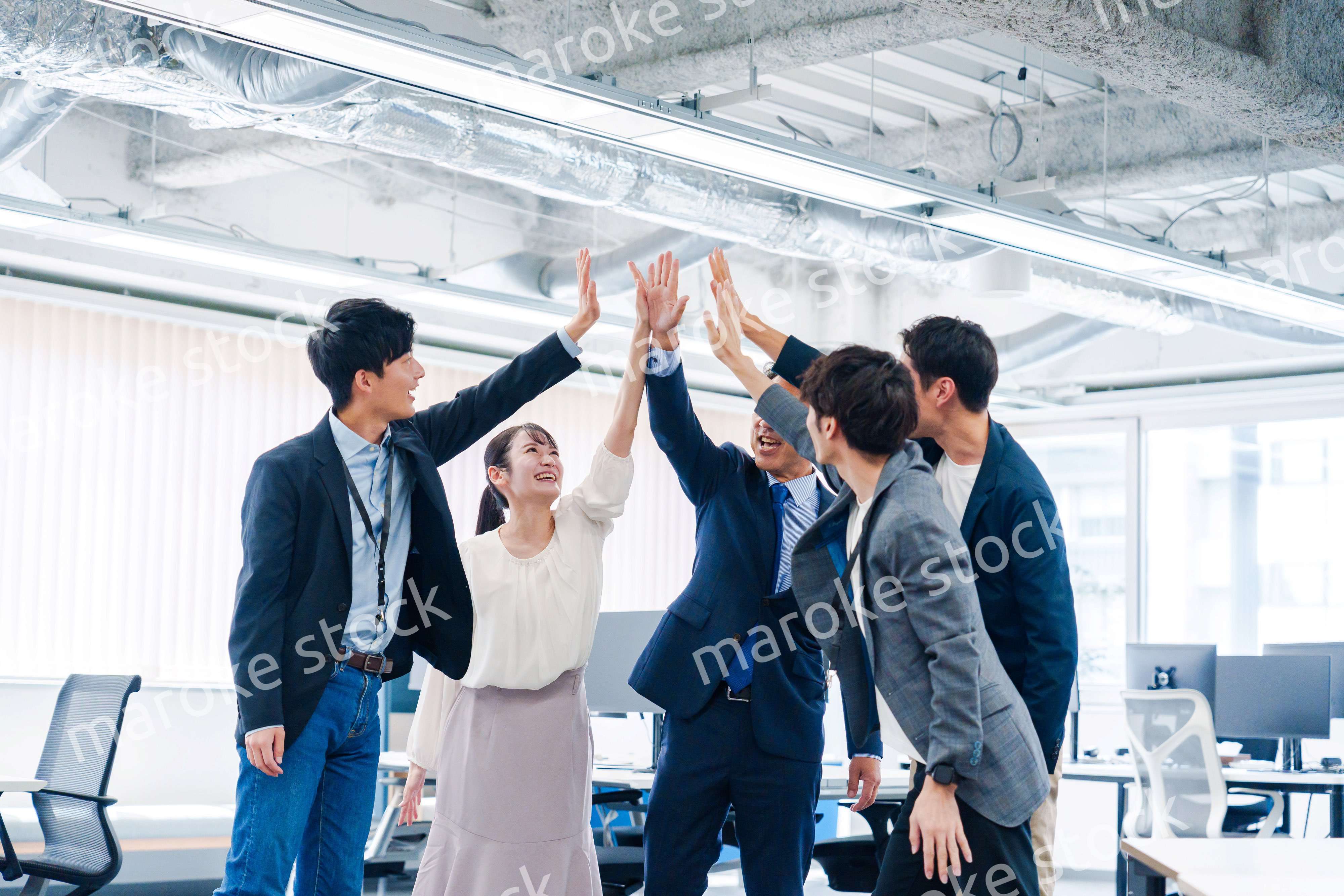 オフィスでハイタッチをするビジネスパーソン
