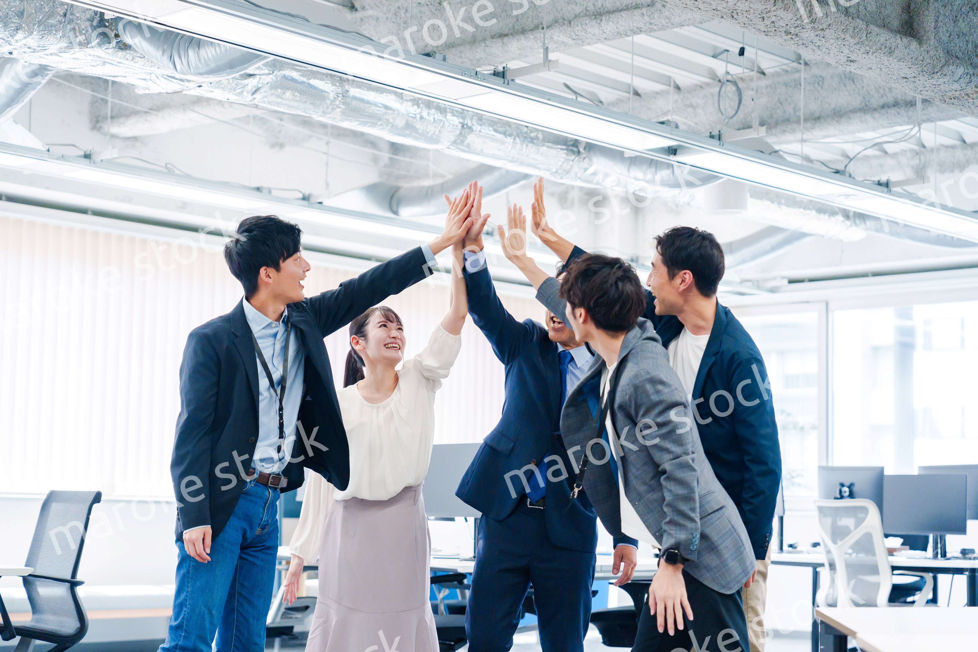 オフィスでハイタッチをするビジネスパーソン