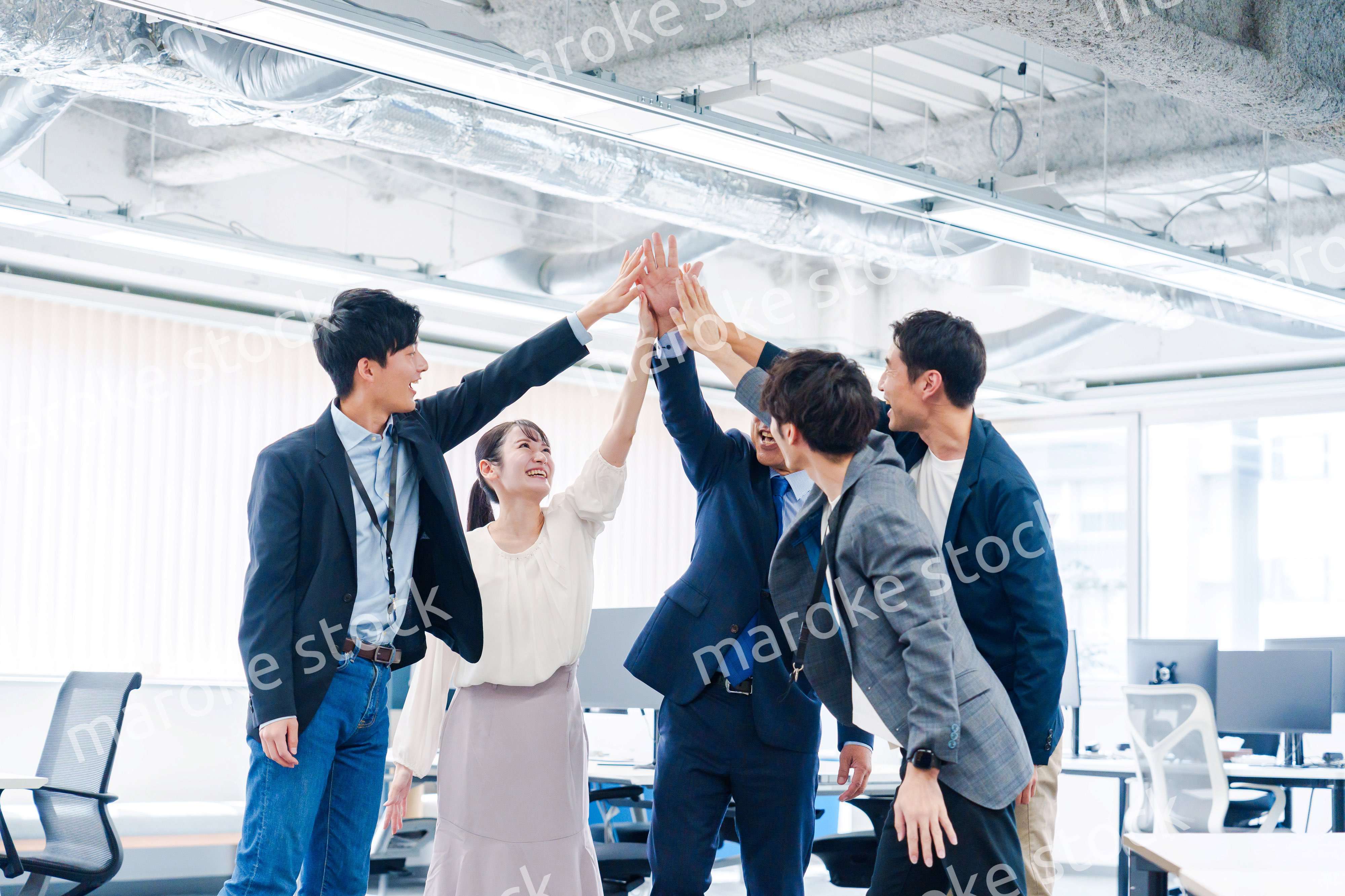 オフィスでハイタッチをするビジネスパーソン