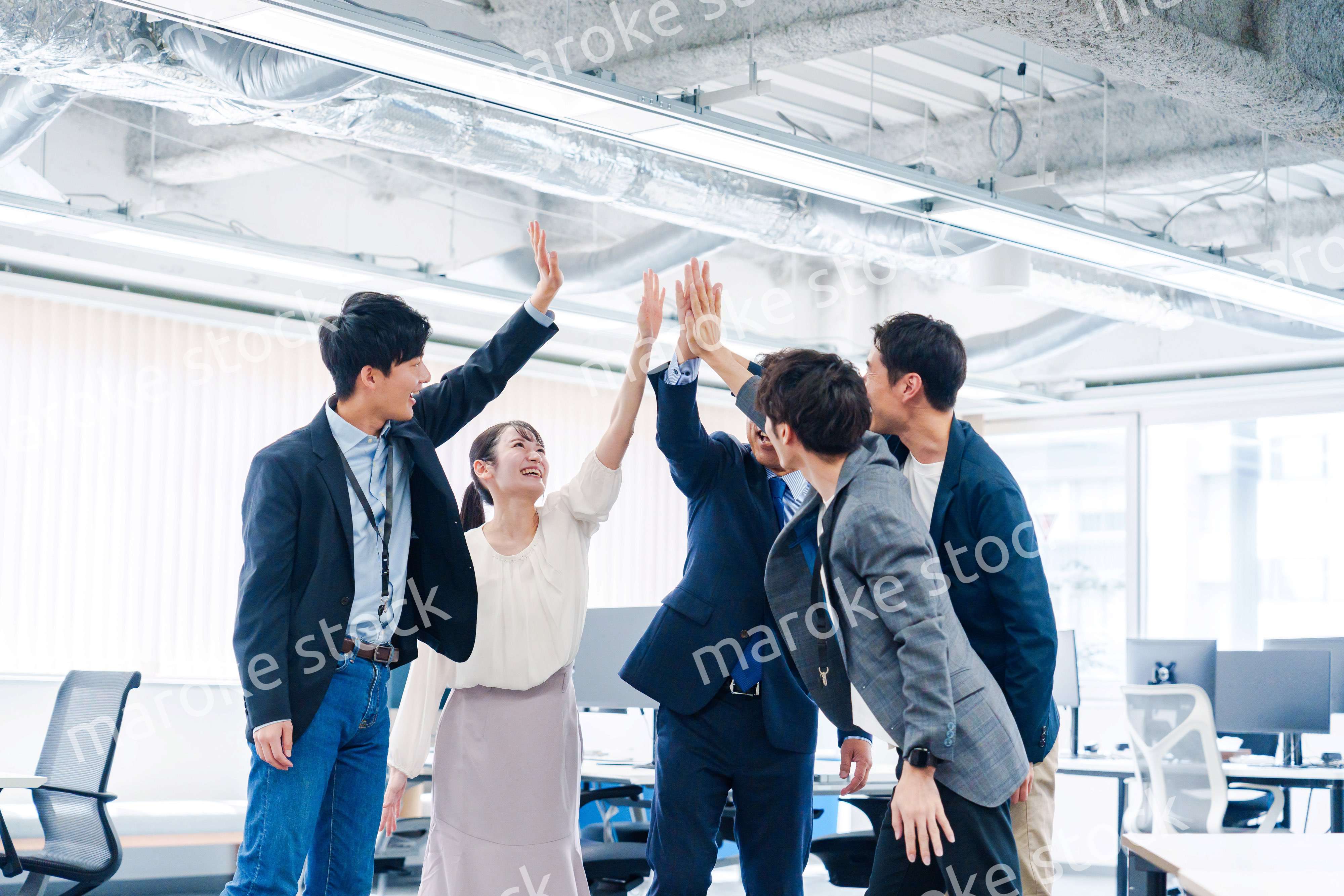 オフィスでハイタッチをするビジネスパーソン
