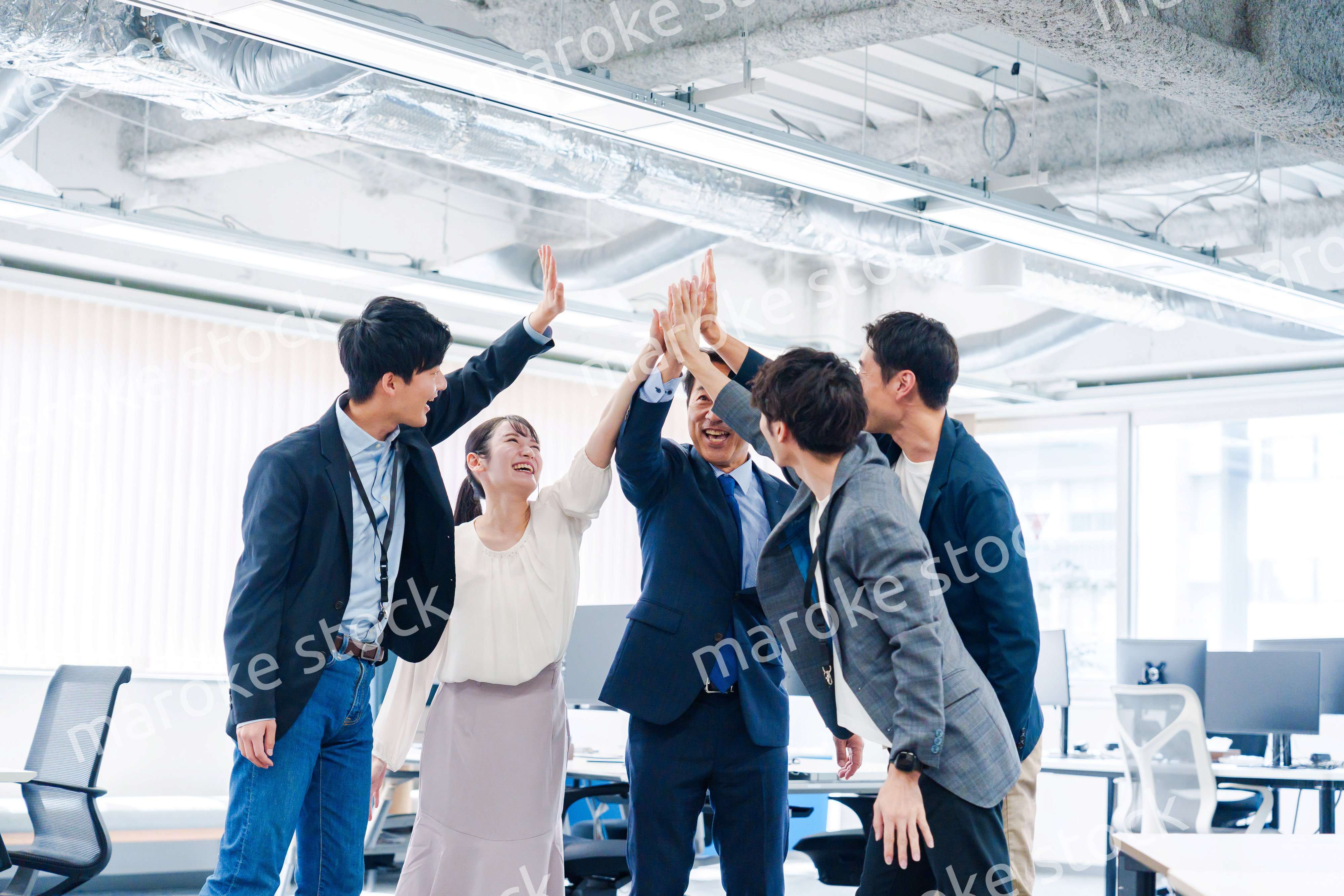 オフィスでハイタッチをするビジネスパーソン