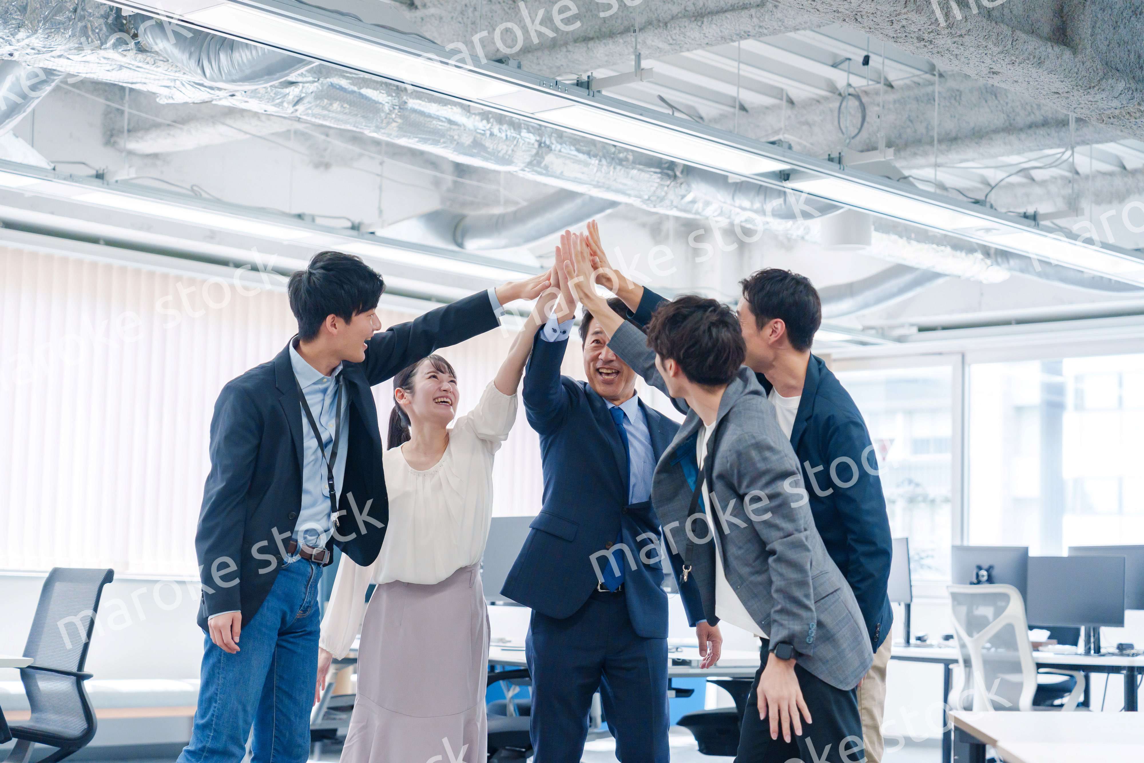 オフィスでハイタッチをするビジネスパーソン