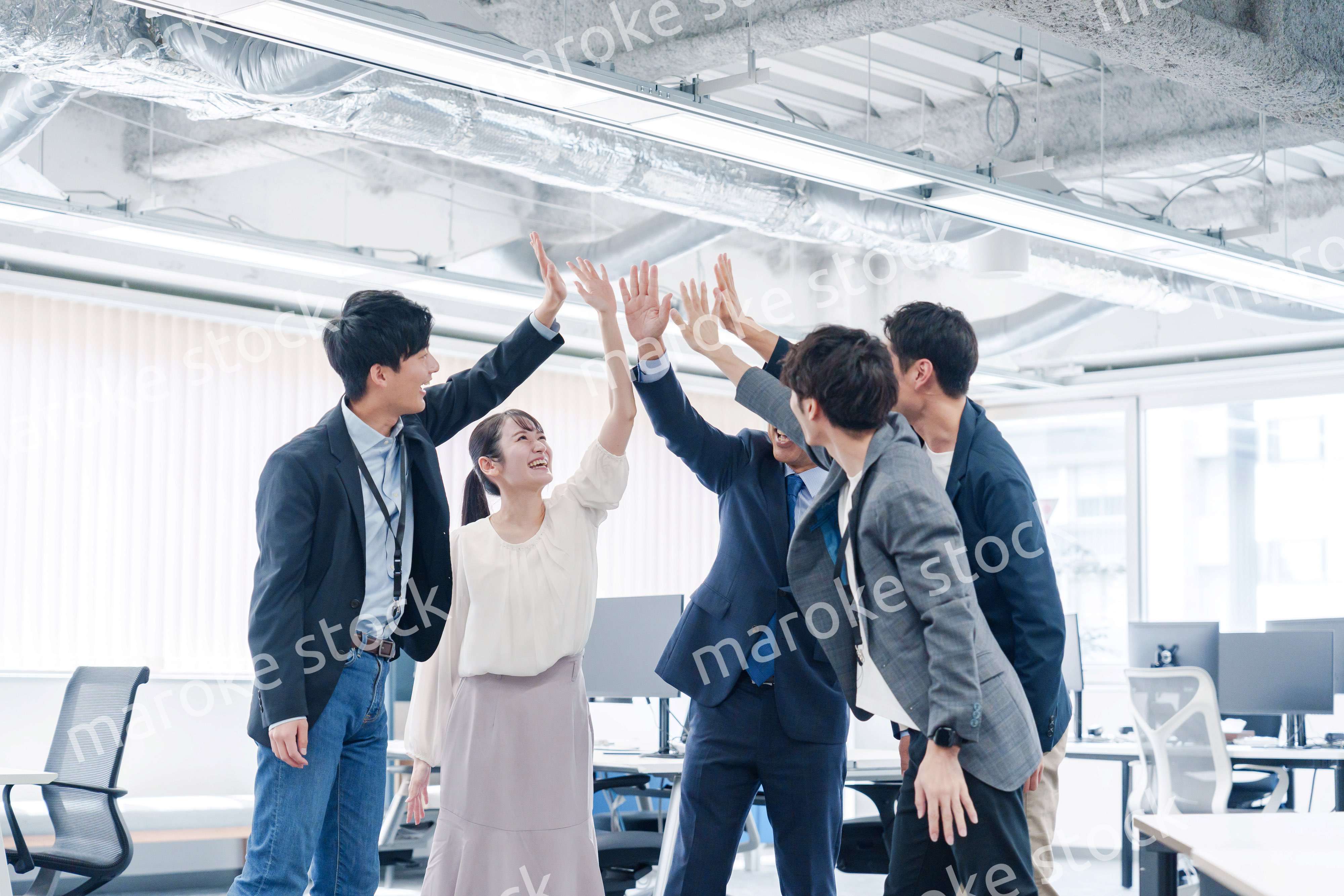 オフィスでハイタッチをするビジネスパーソン