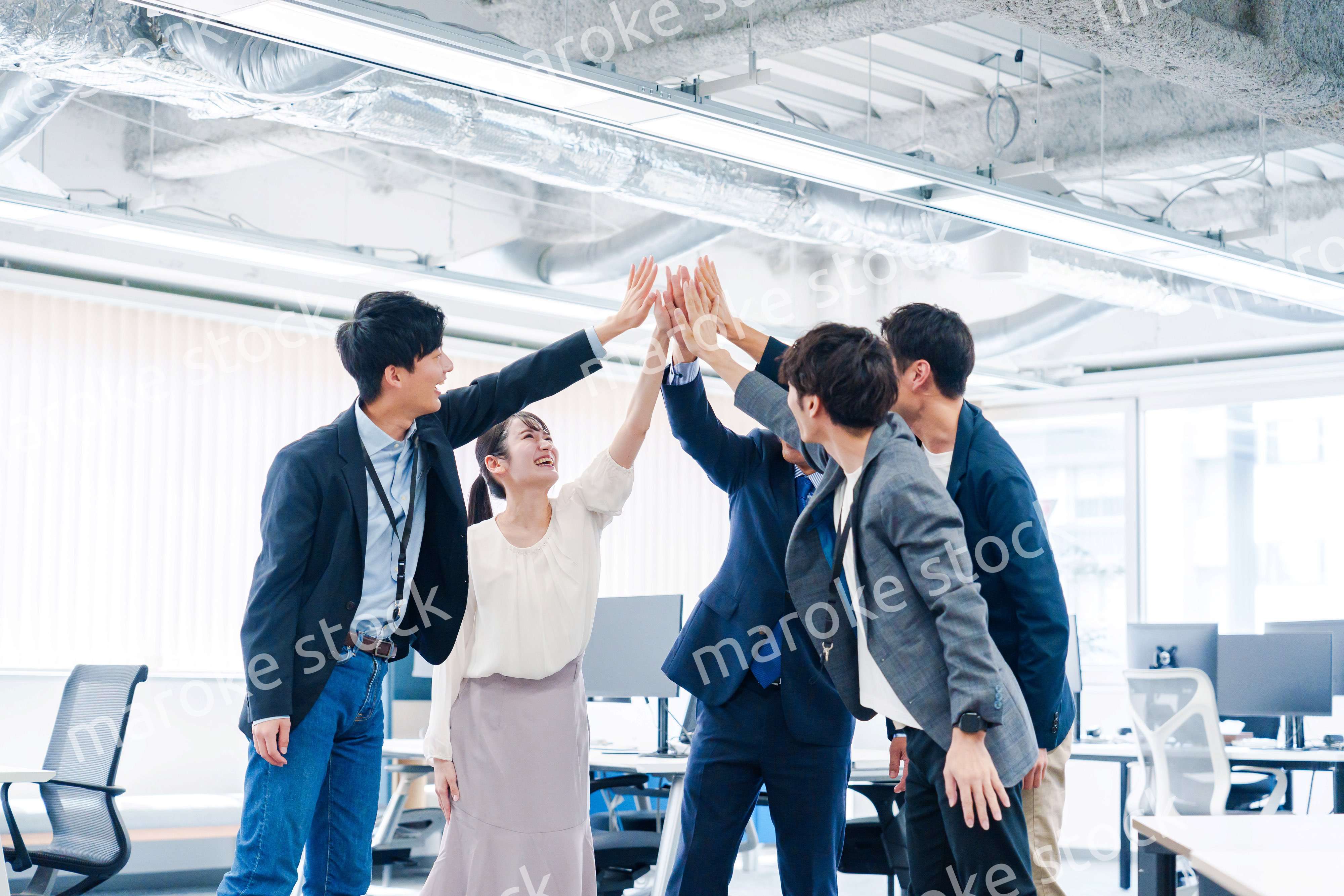 オフィスでハイタッチをするビジネスパーソン