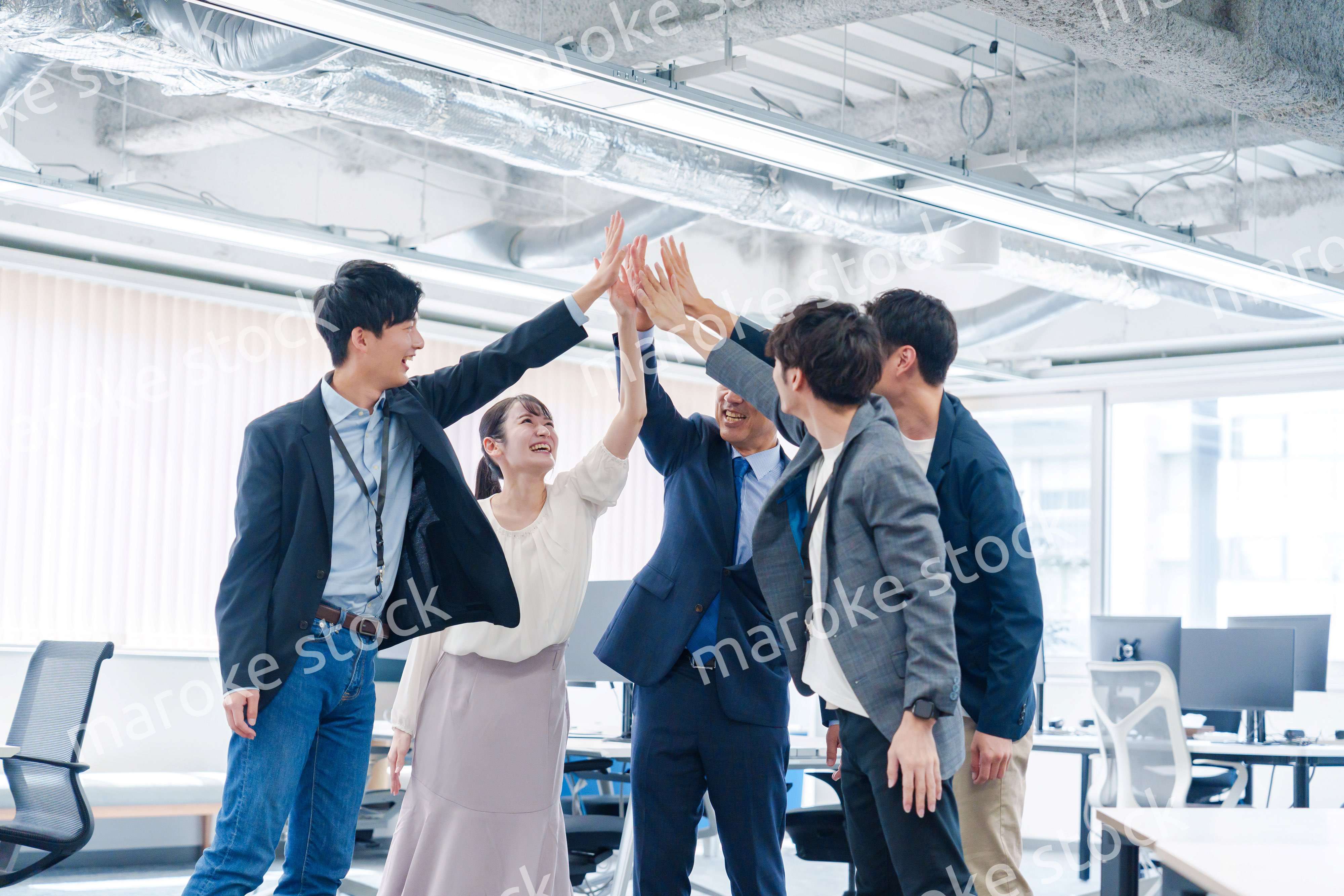 オフィスでハイタッチをするビジネスパーソン