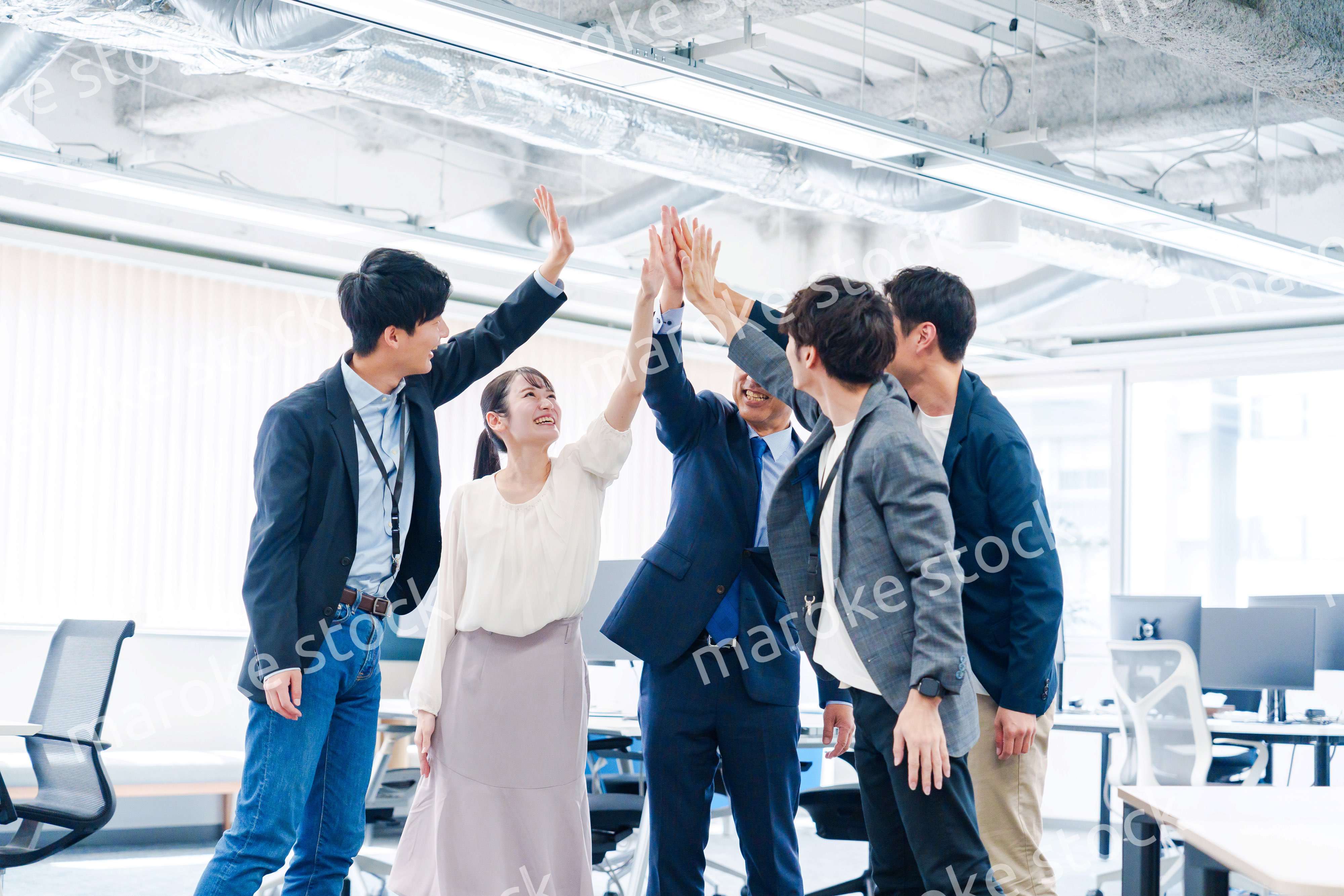 オフィスでハイタッチをするビジネスパーソン
