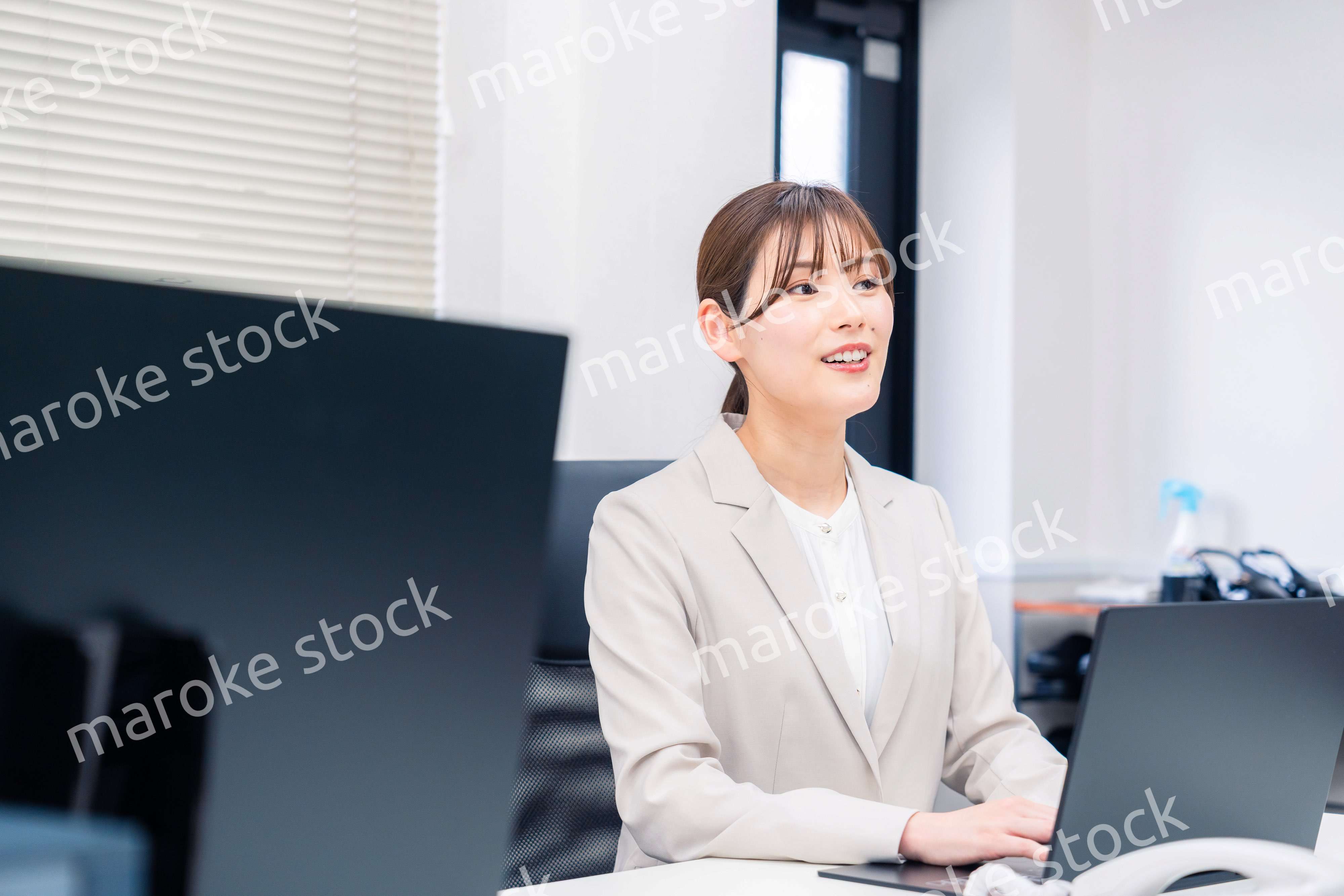 役所でデスクワークをする公務員の若い女性