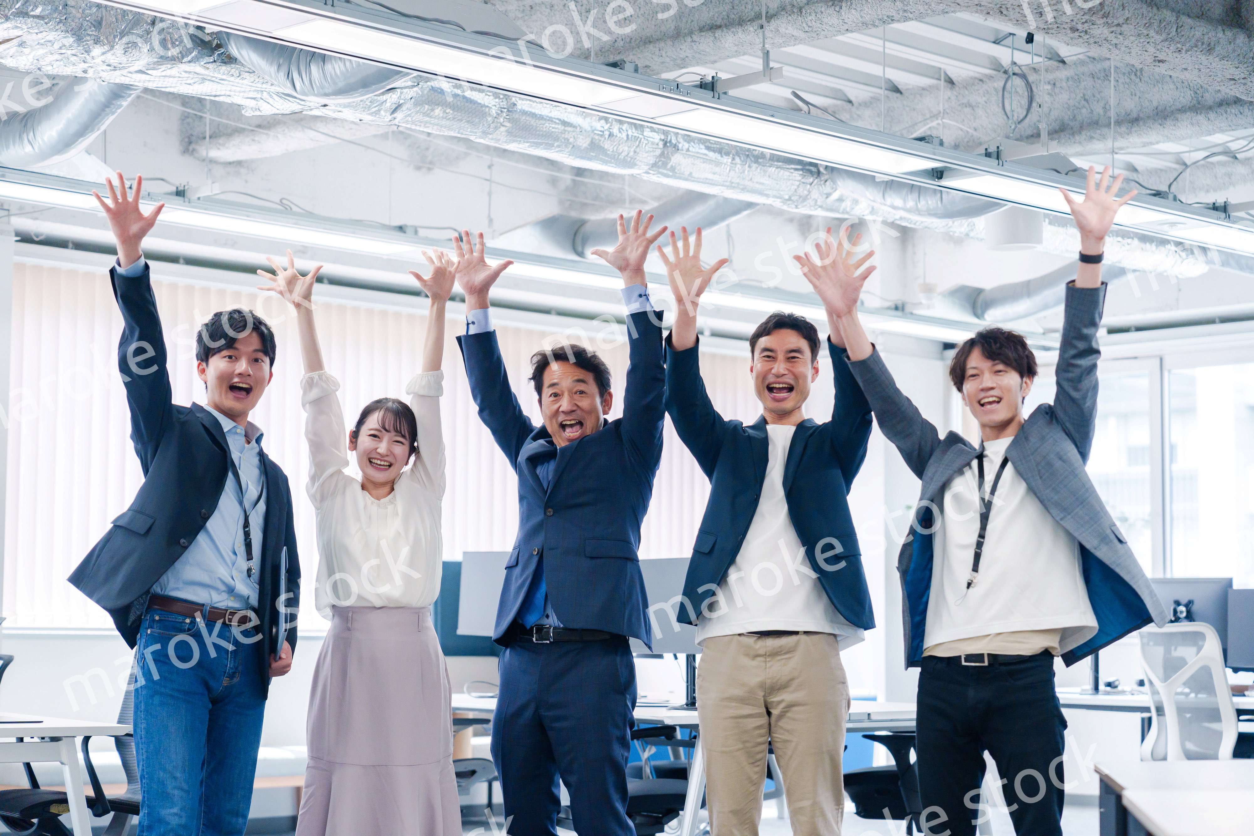 オフィスで大喜びをしてジャンプをするビジネスパーソン