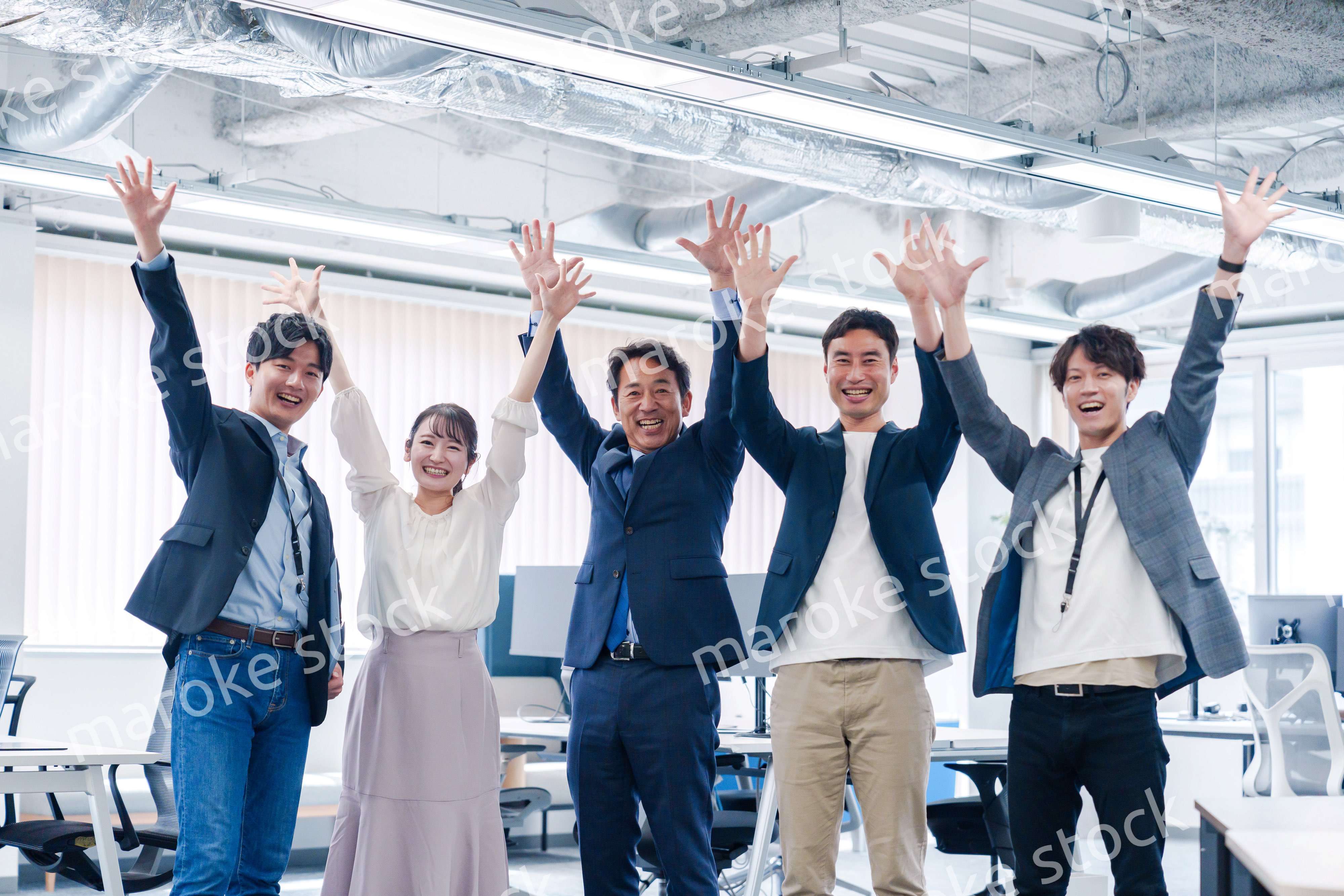 オフィスで大喜びをしてジャンプをするビジネスパーソン