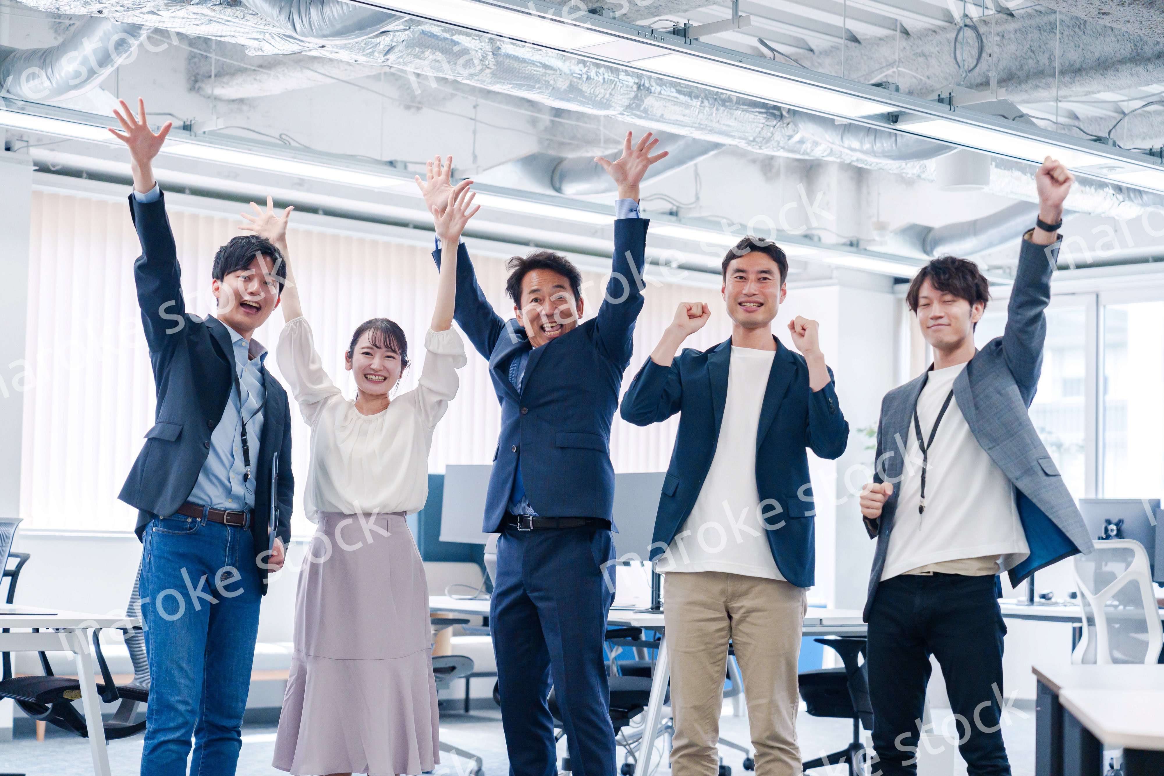 オフィスで大喜びをしてジャンプをするビジネスパーソン