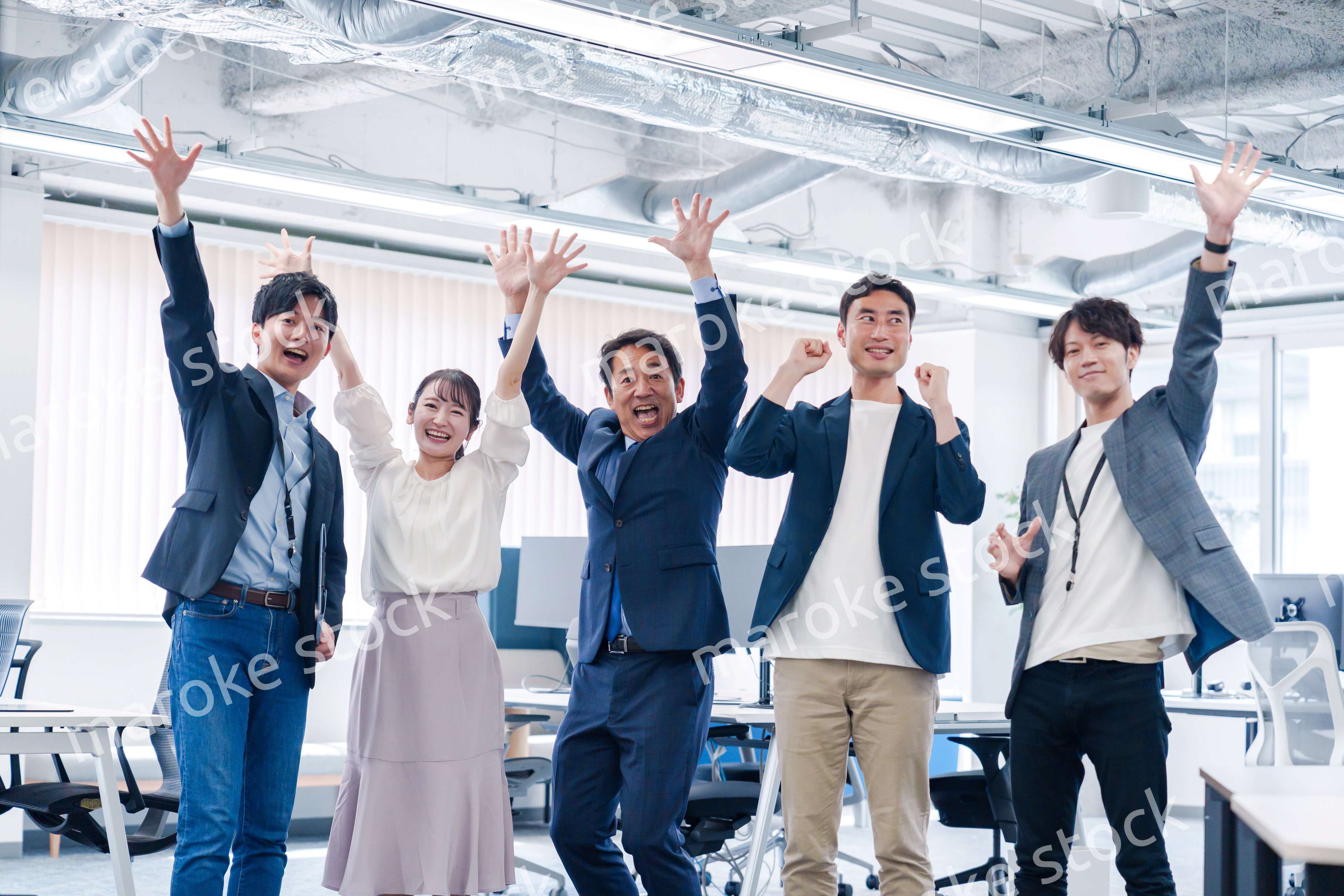 オフィスで大喜びをしてジャンプをするビジネスパーソン