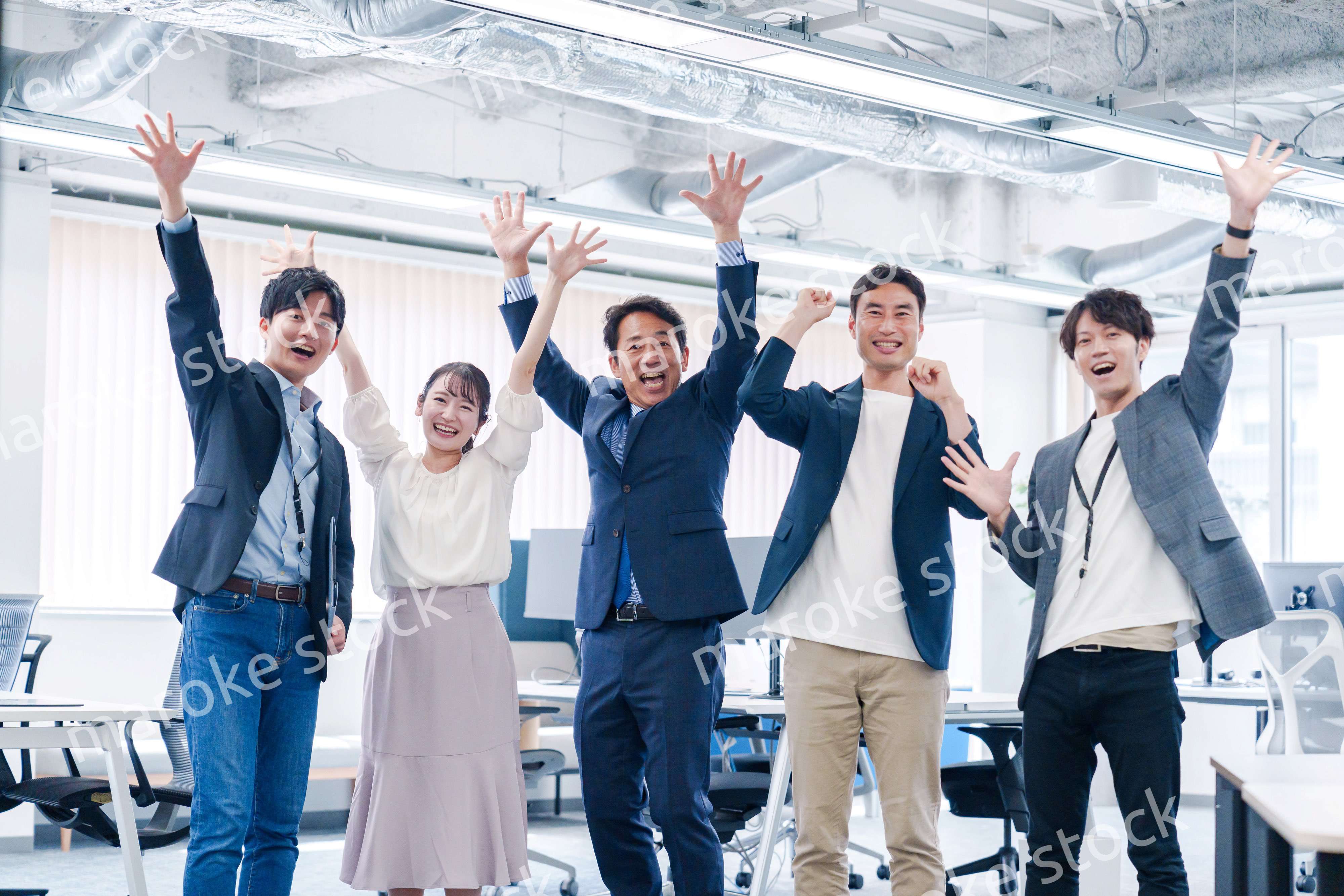 オフィスで大喜びをしてジャンプをするビジネスパーソン