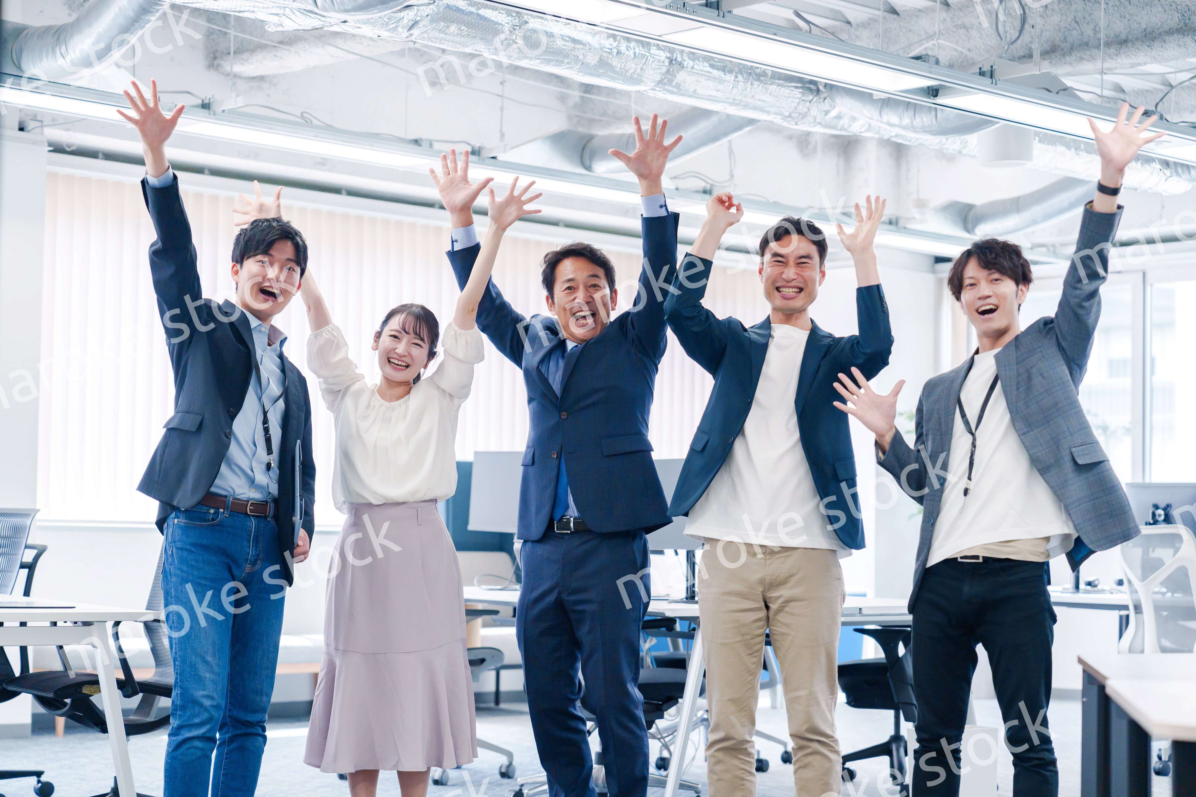 オフィスで大喜びをしてジャンプをするビジネスパーソン