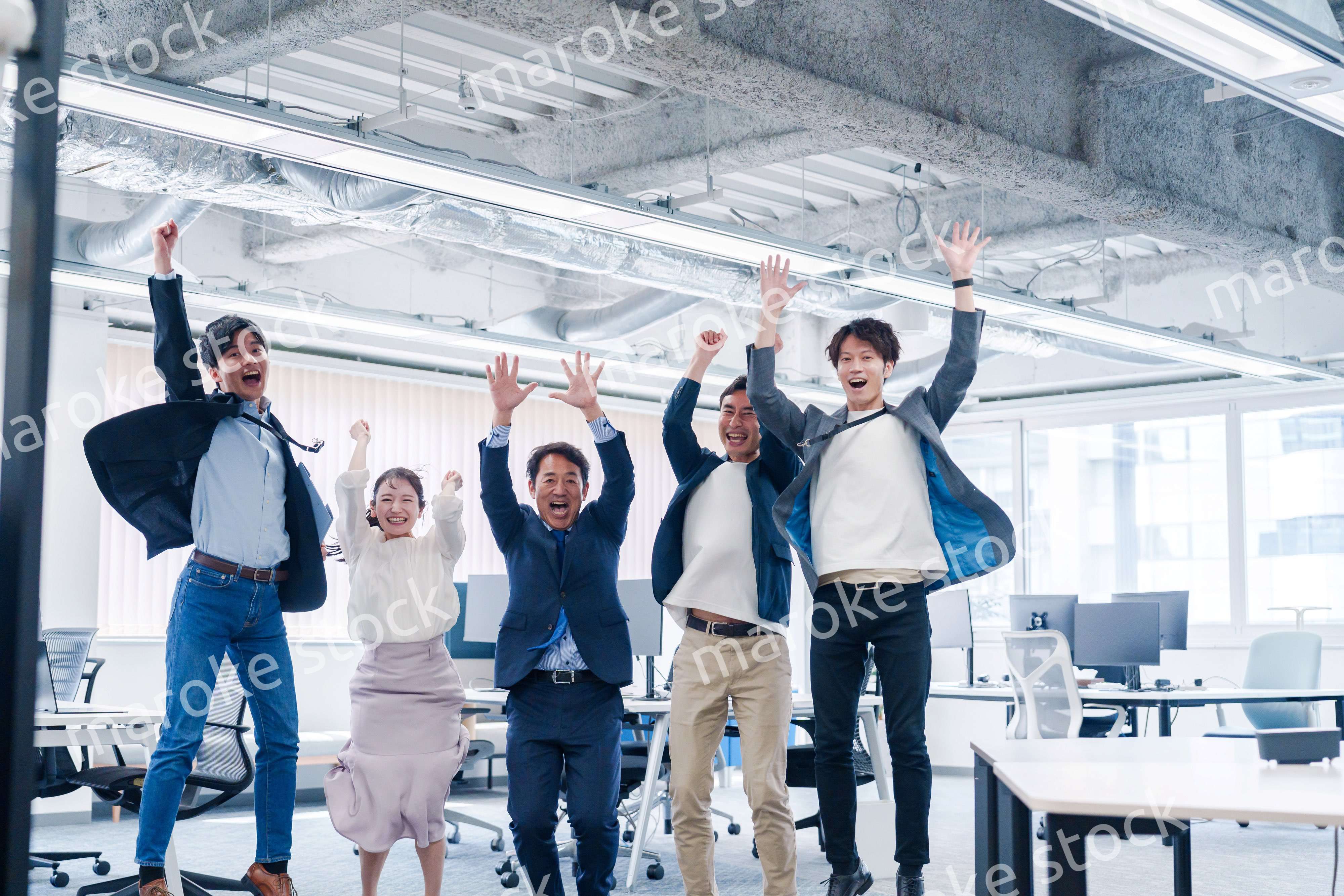 オフィスで大喜びをしてジャンプをするビジネスパーソン