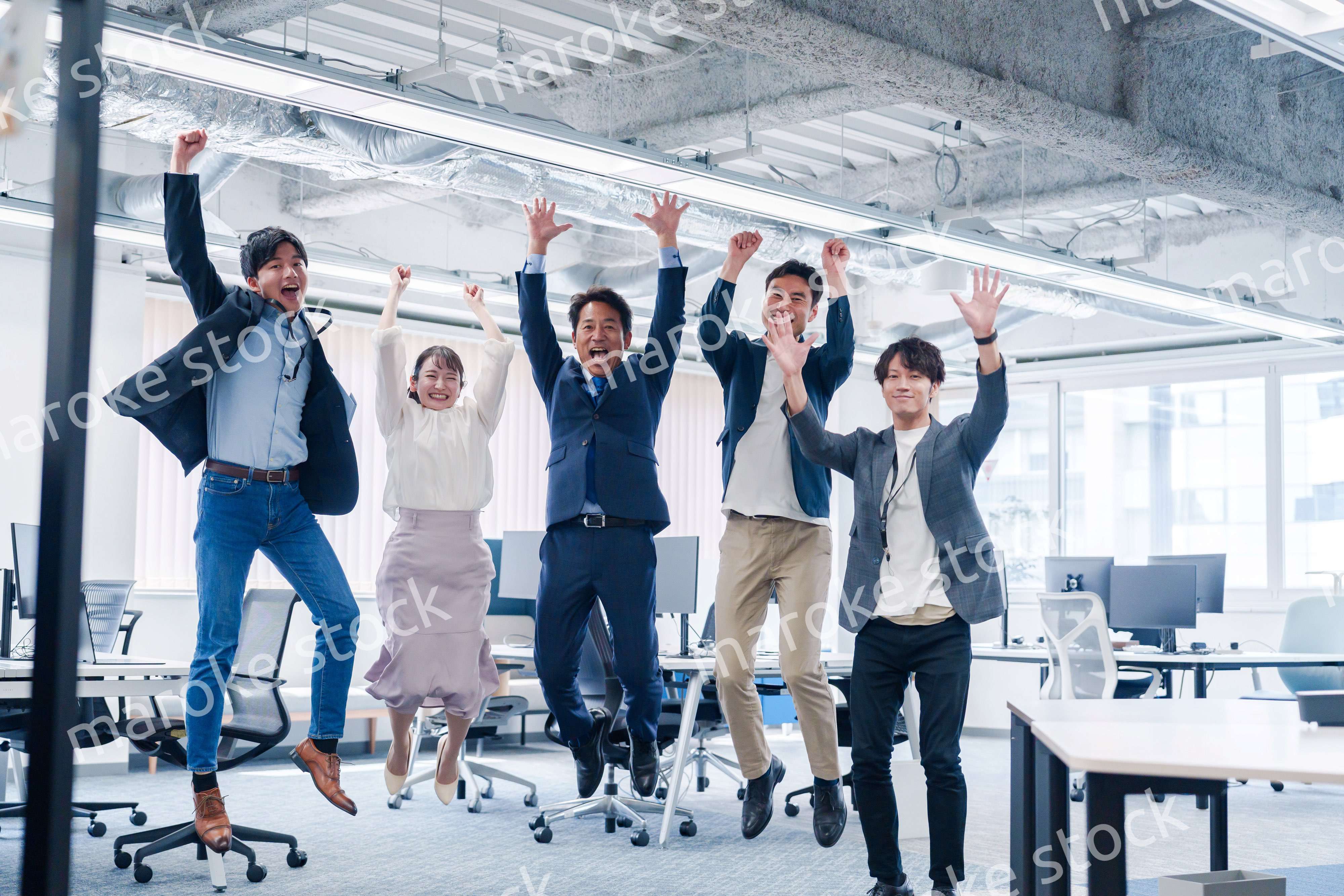 オフィスで大喜びをしてジャンプをするビジネスパーソン