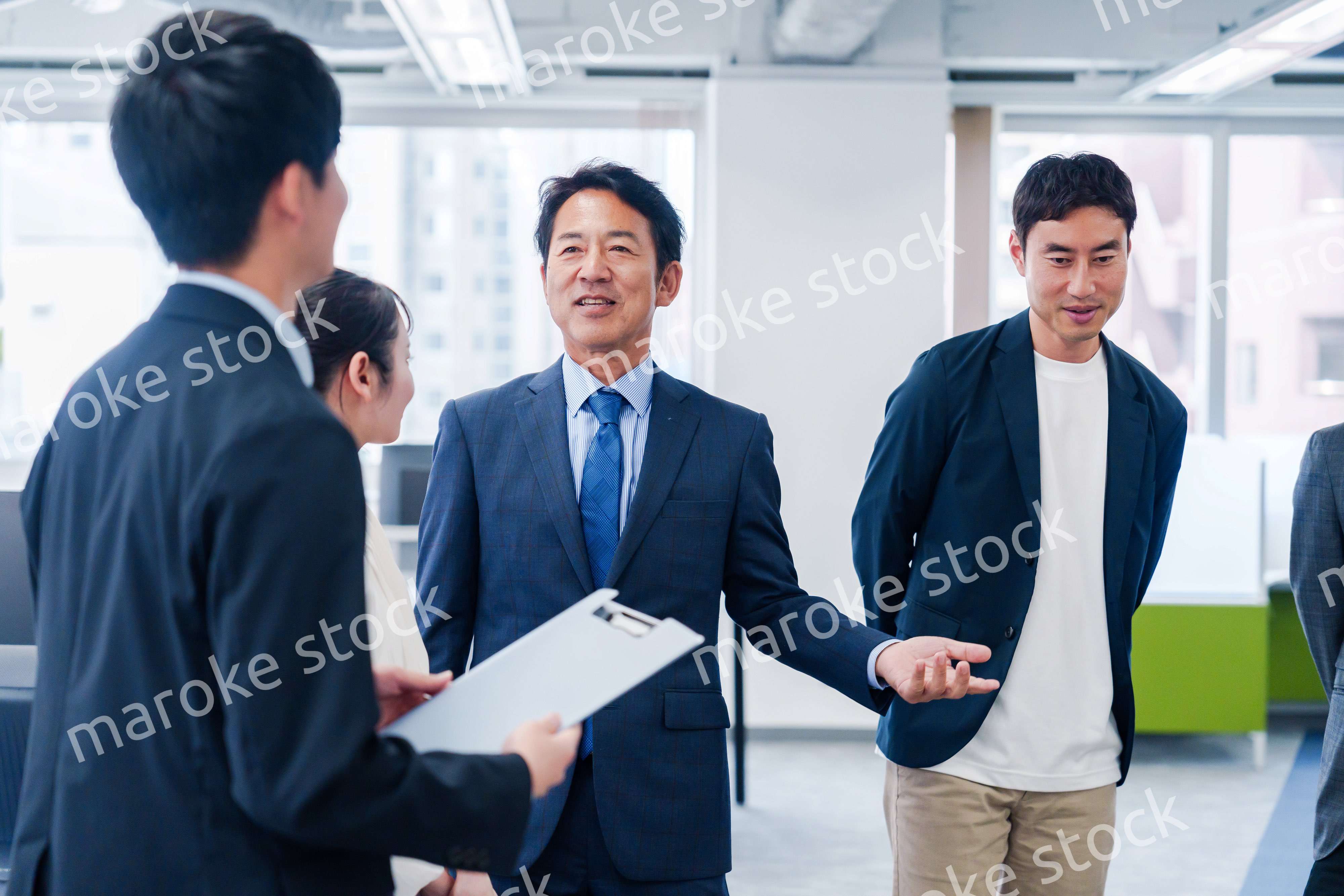オフィスで立ち話をするビジネスパーソン
