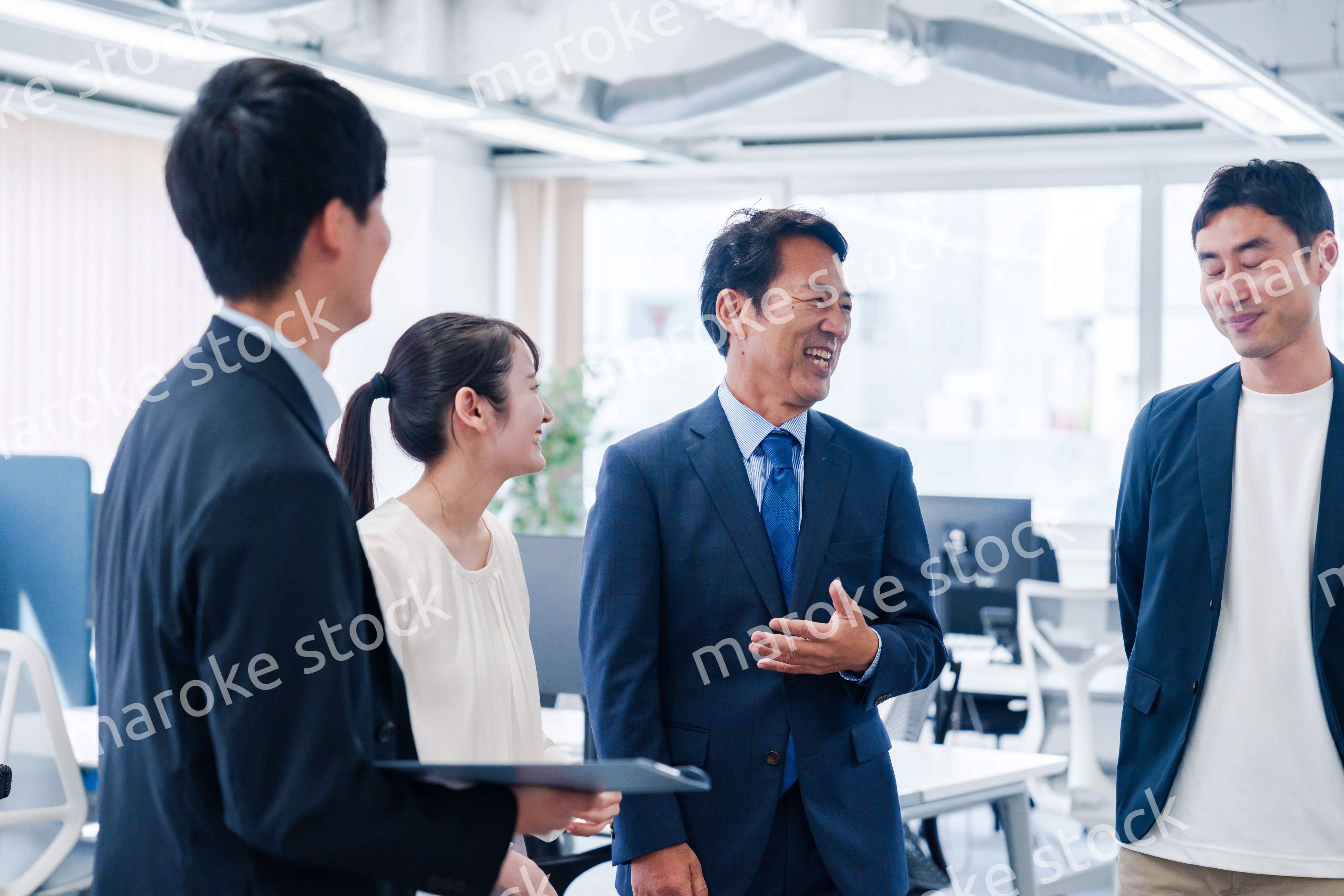 オフィスで立ち話をするビジネスパーソン