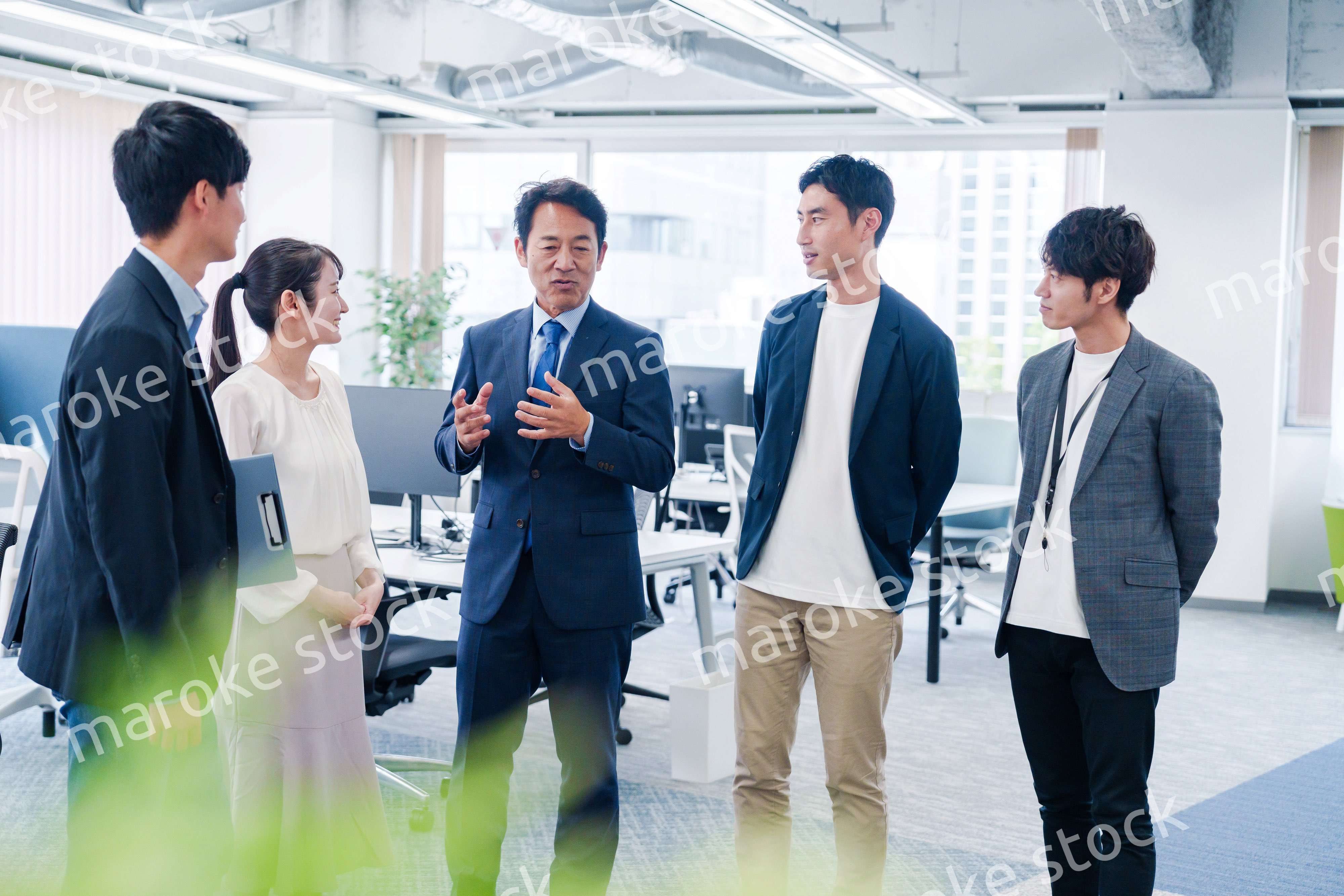 オフィスで立ち話をするビジネスパーソン