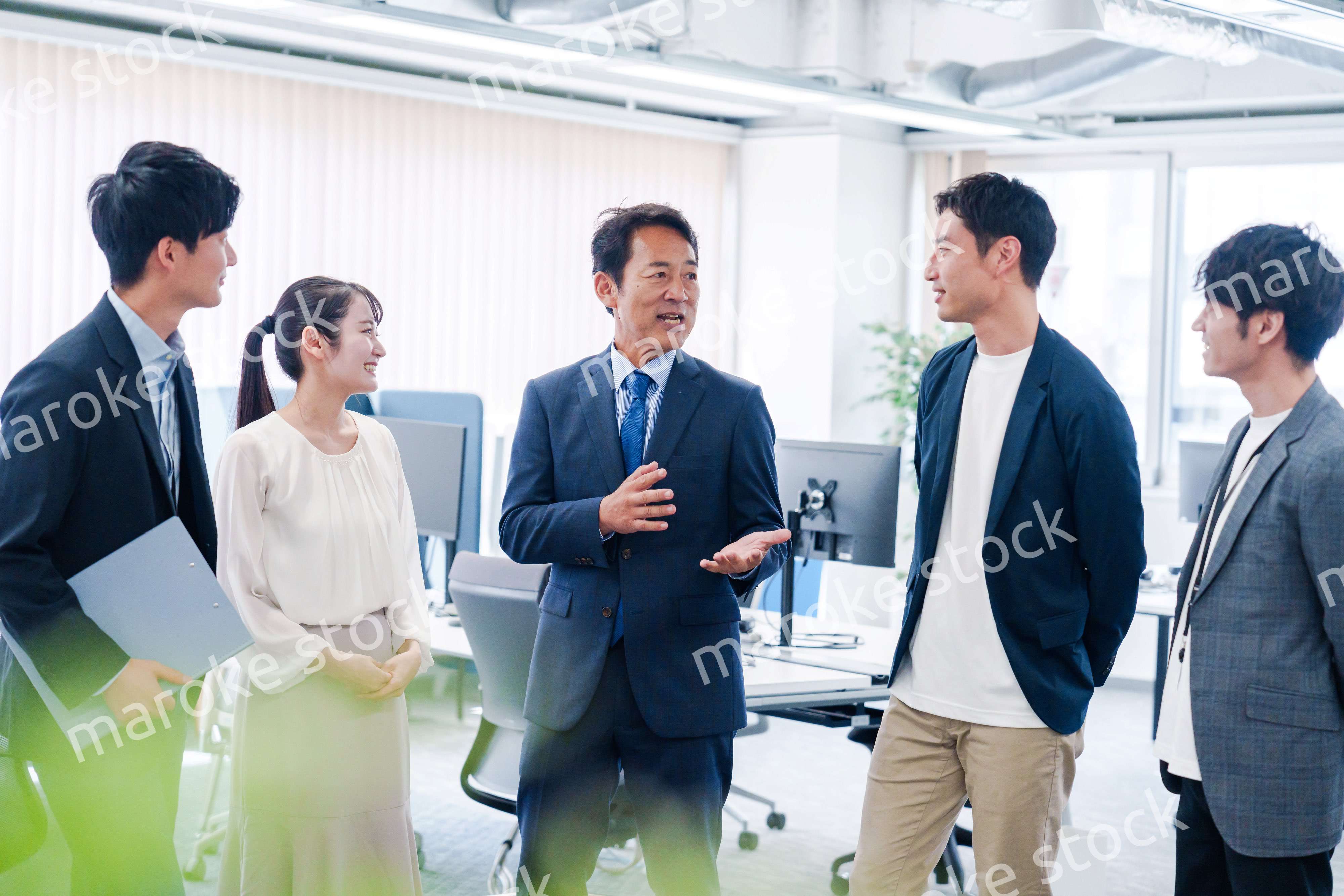 オフィスで立ち話をするビジネスパーソン