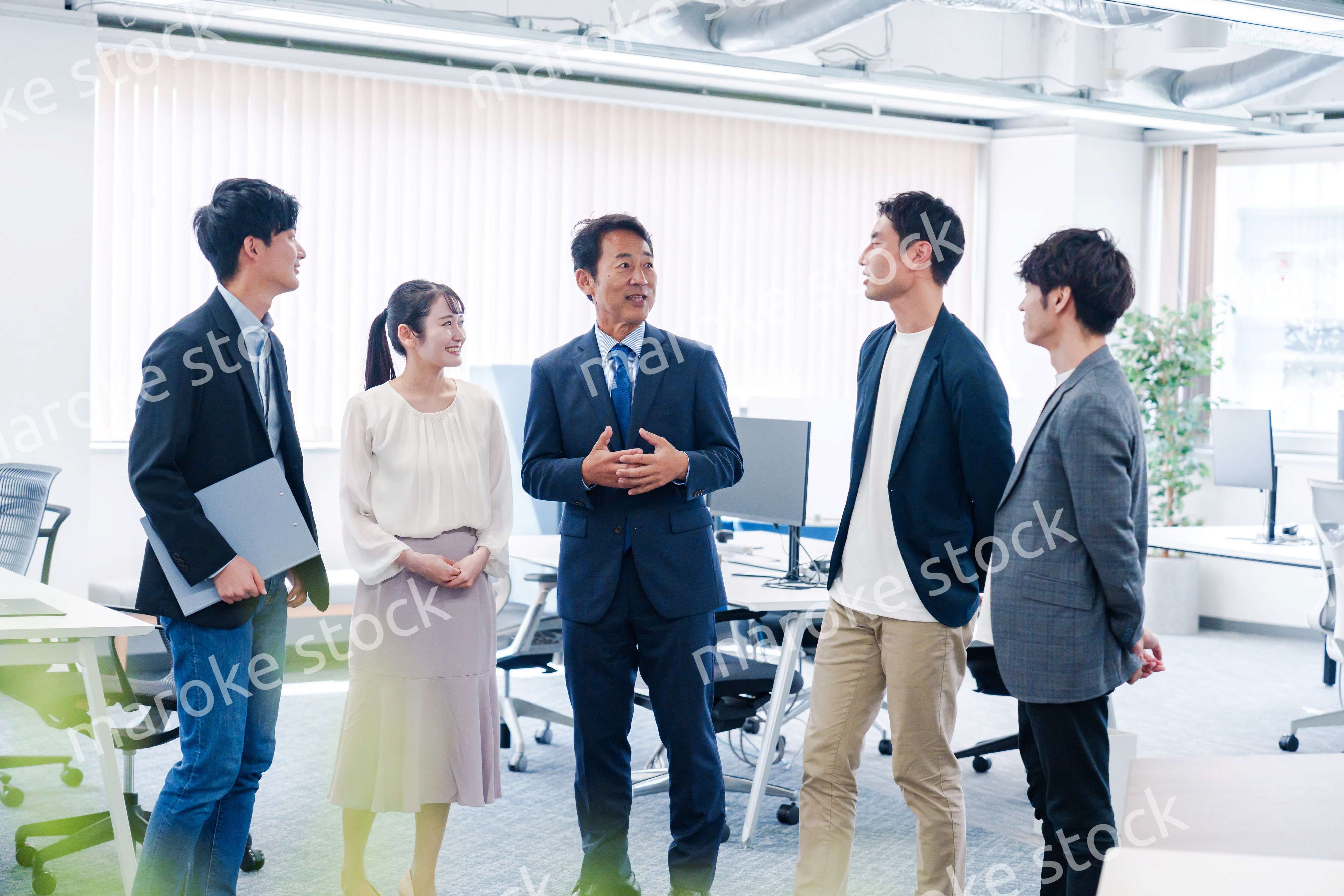 オフィスで立ち話をするビジネスパーソン