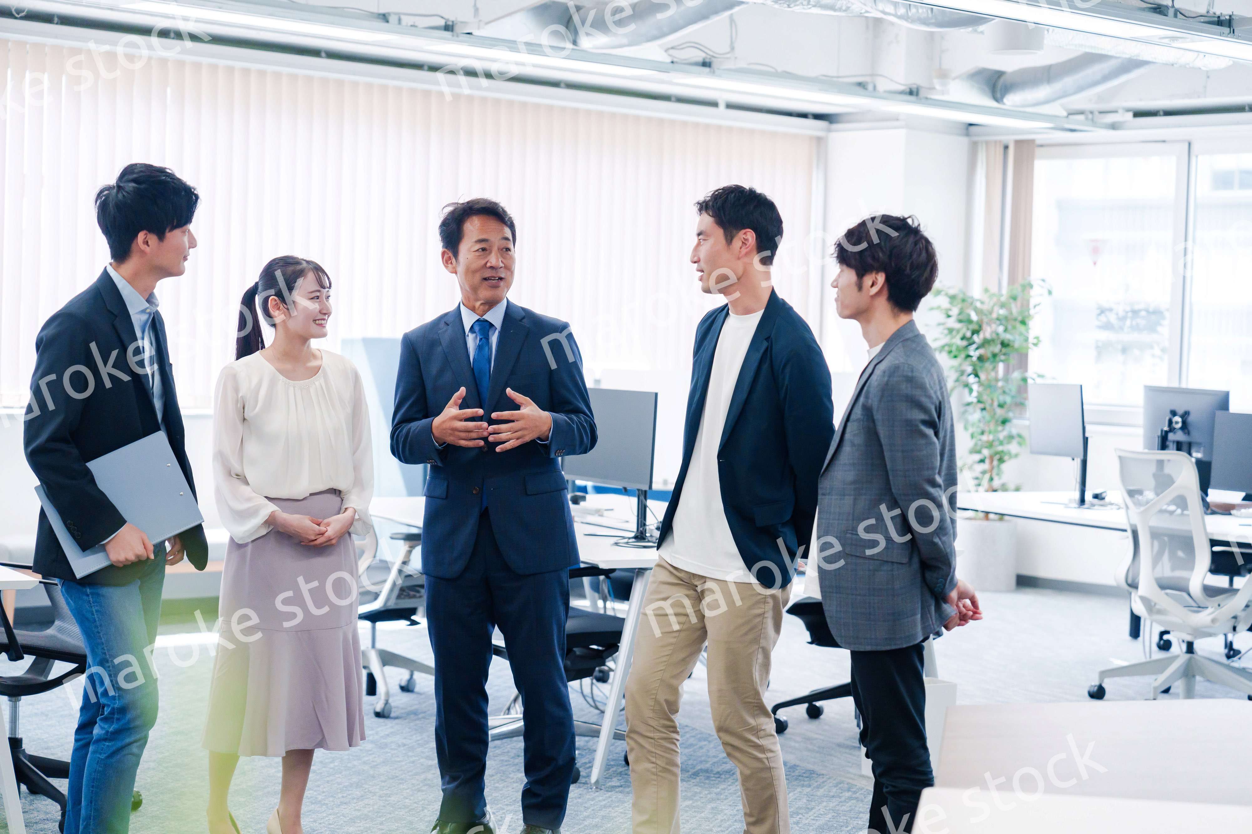 オフィスで立ち話をするビジネスパーソン