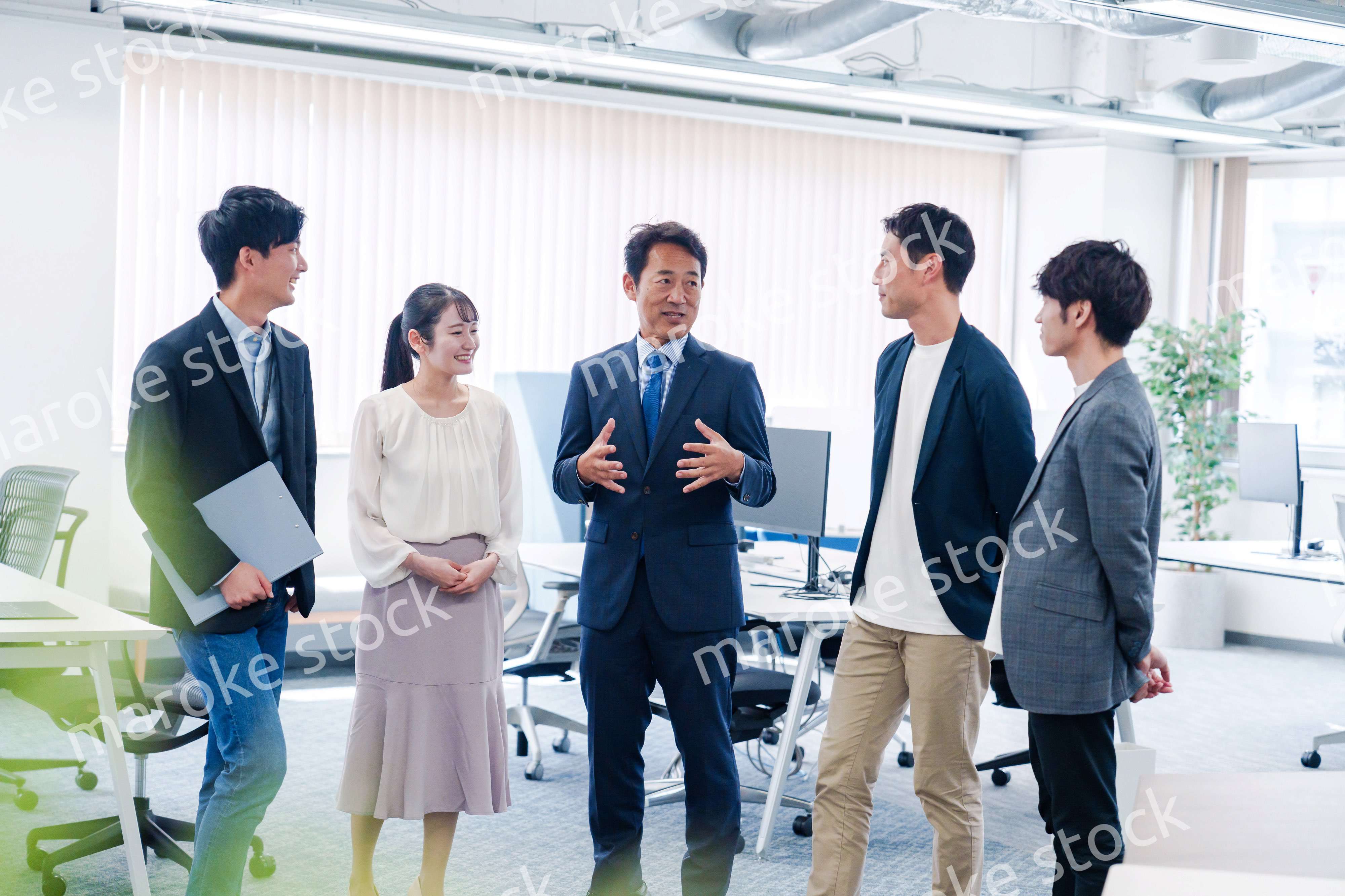 オフィスで立ち話をするビジネスパーソン