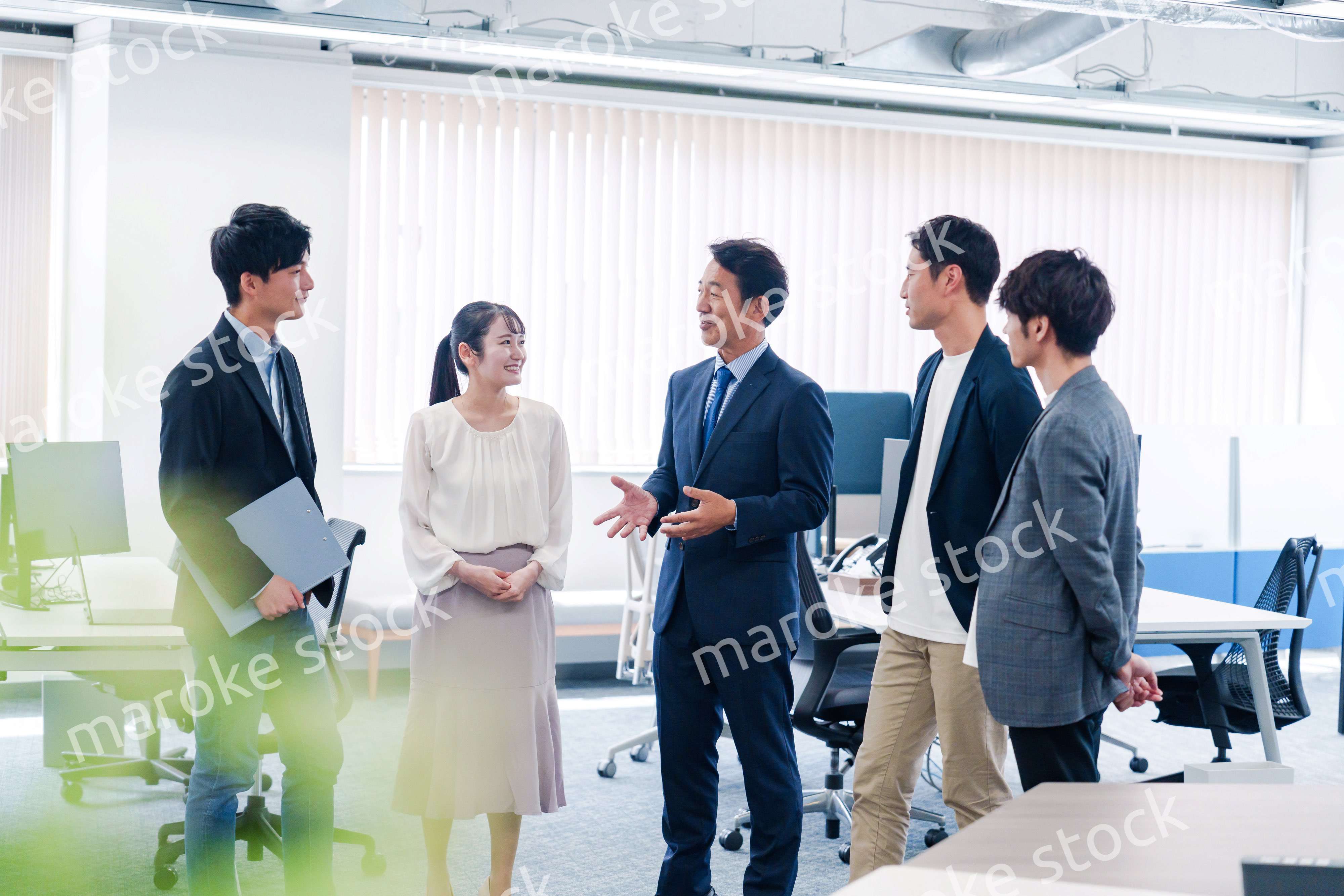 オフィスで立ち話をするビジネスパーソン