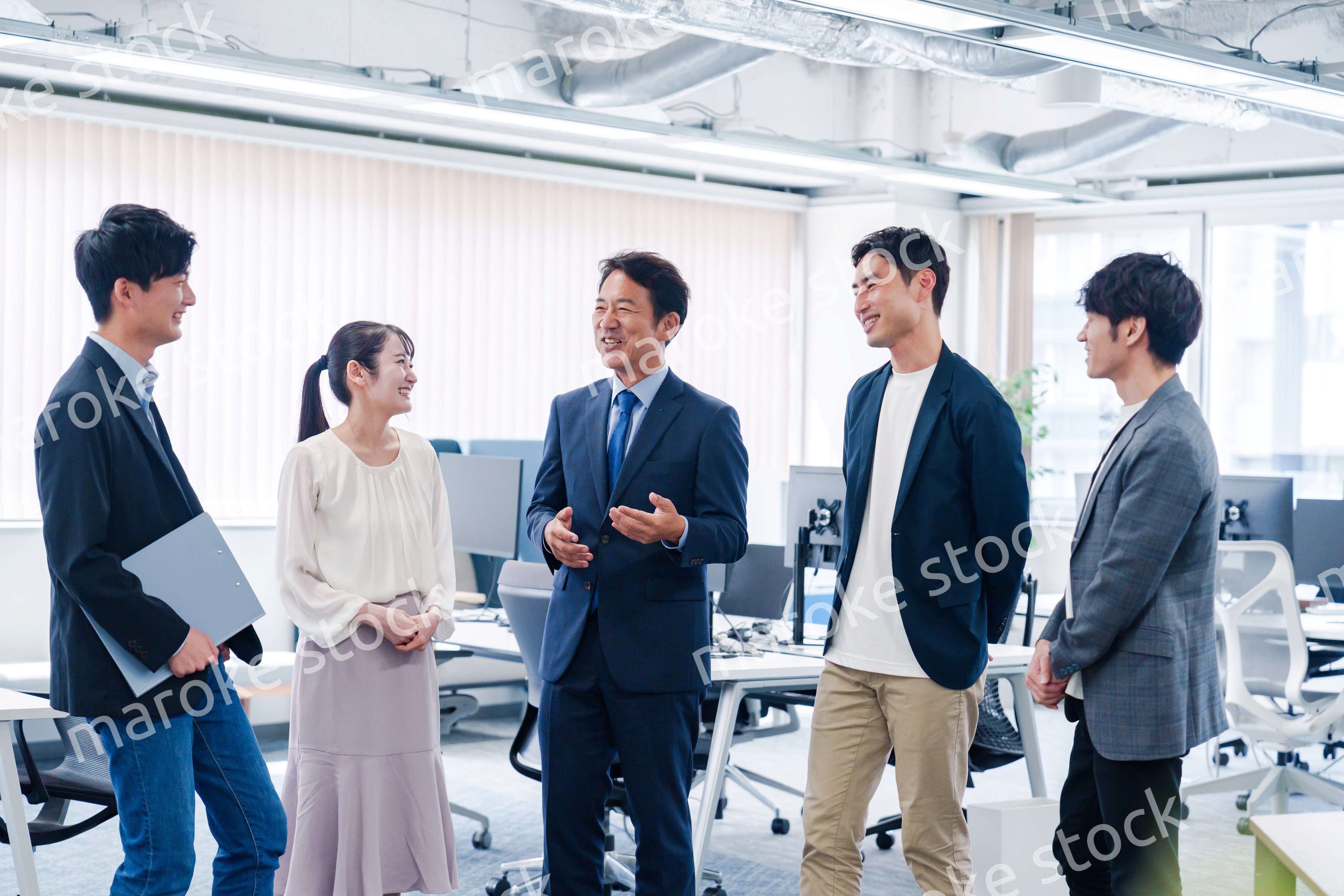 オフィスで立ち話をするビジネスパーソン