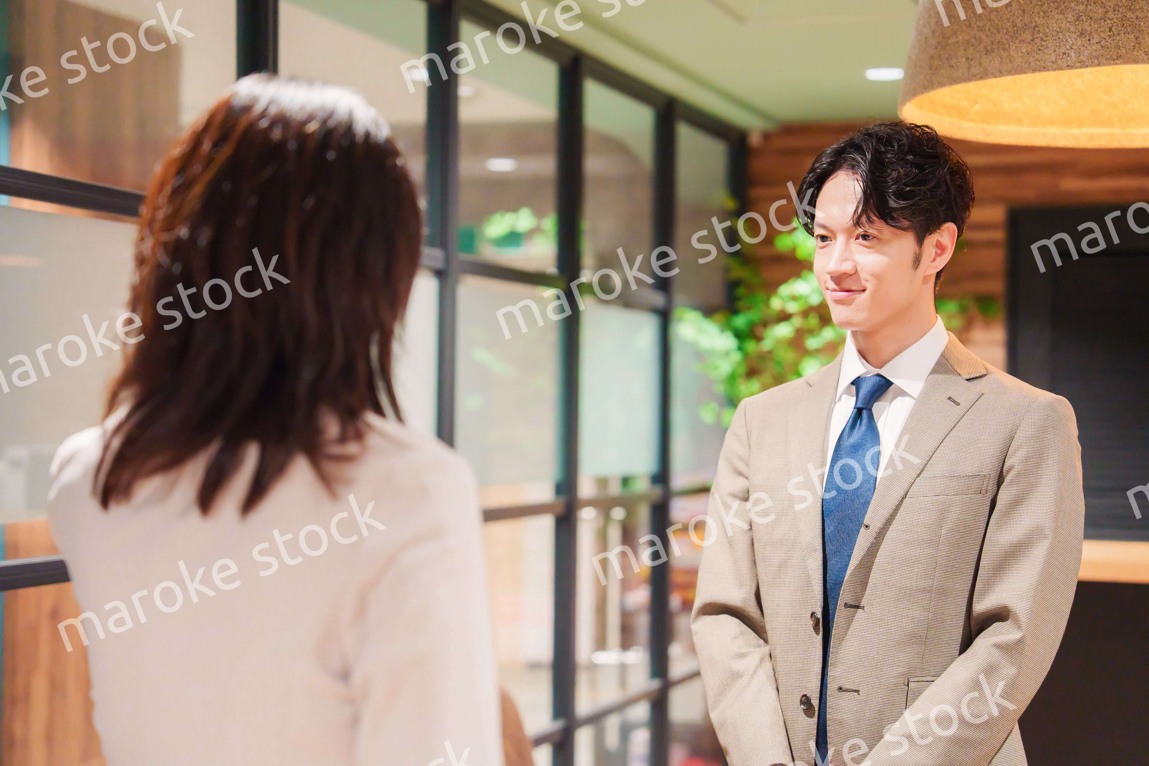 オフィスにお客様を通す女性の秘書