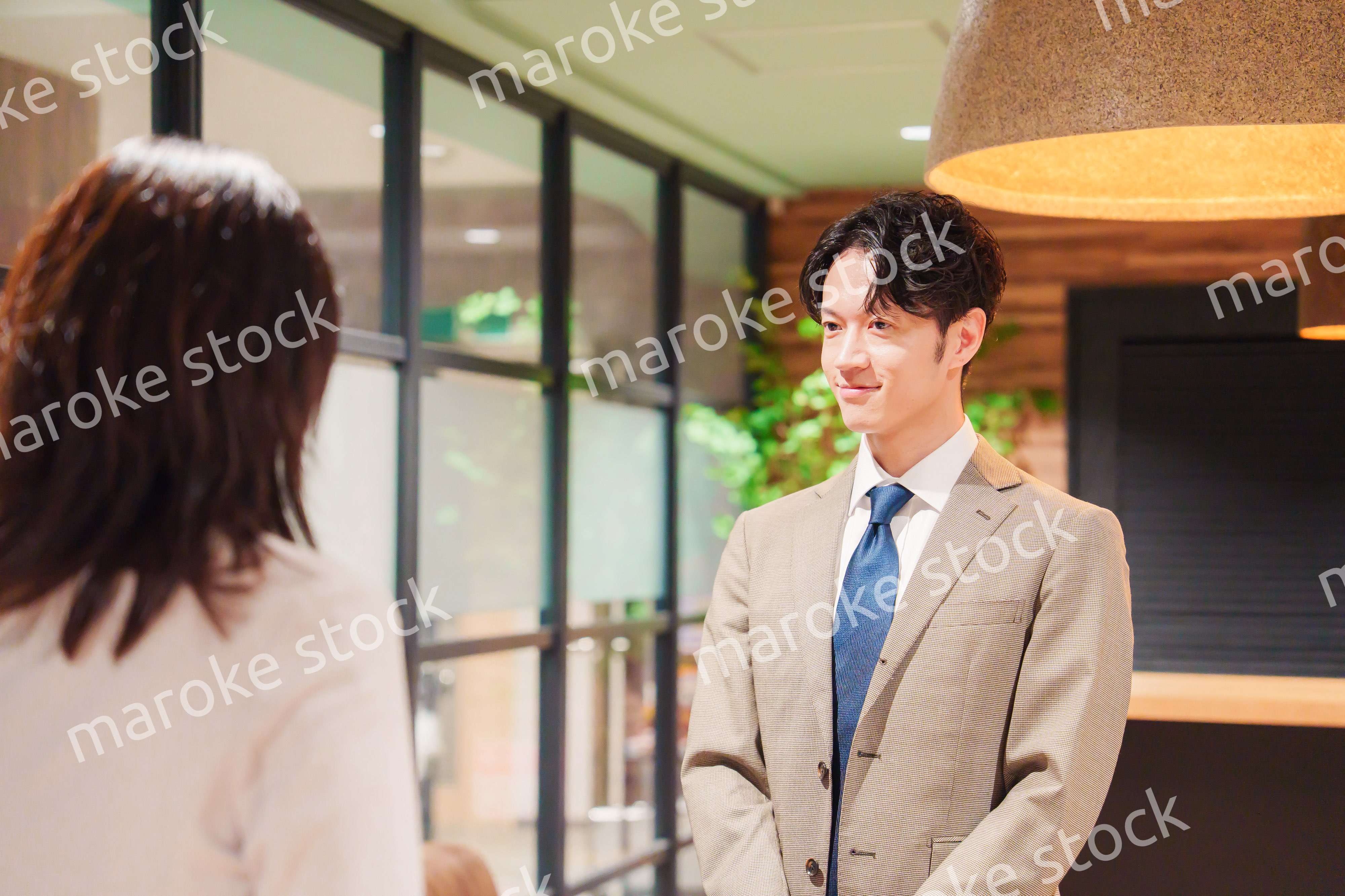 オフィスにお客様を通す女性の秘書