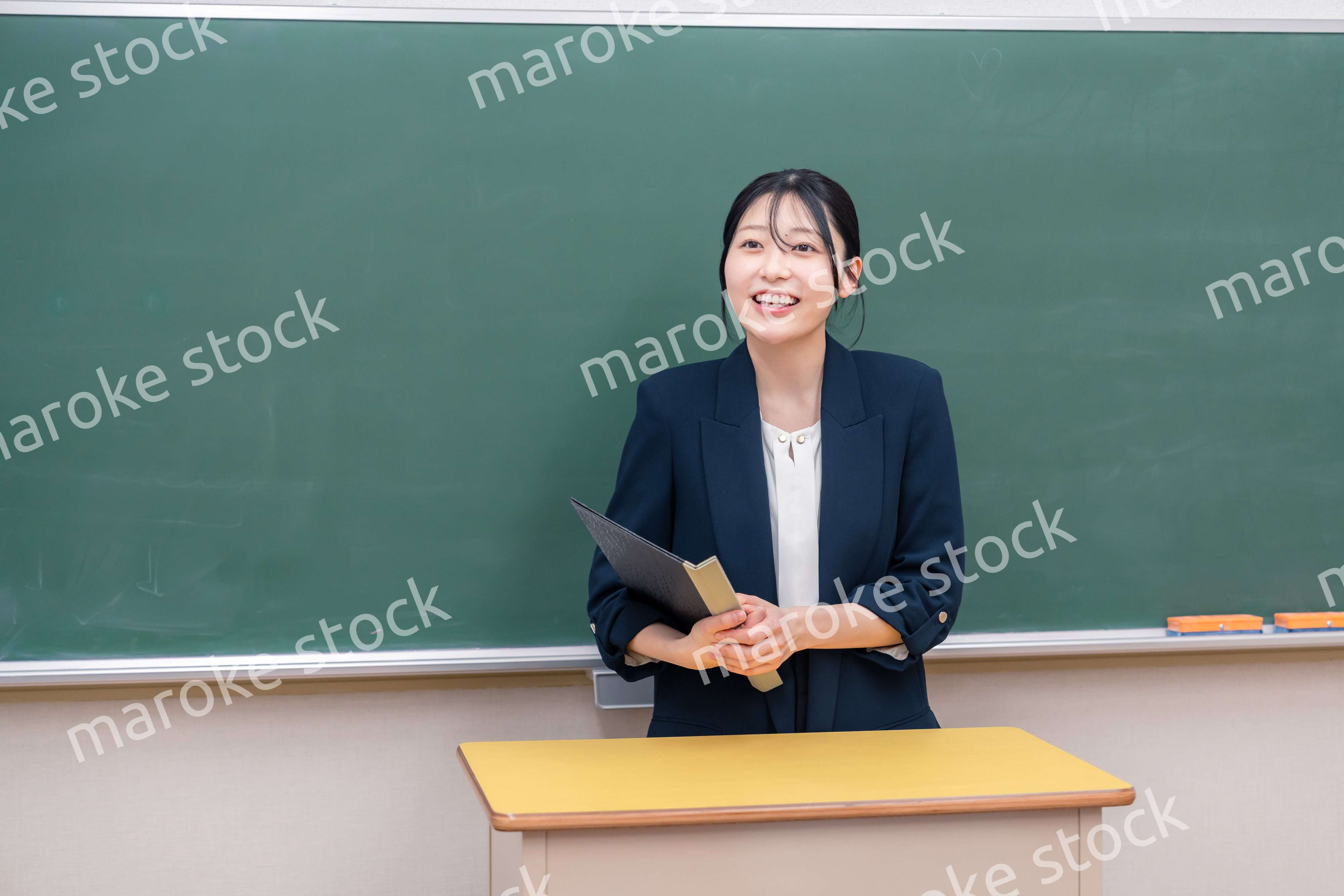 学校で教壇に立って授業をする若い女性教師