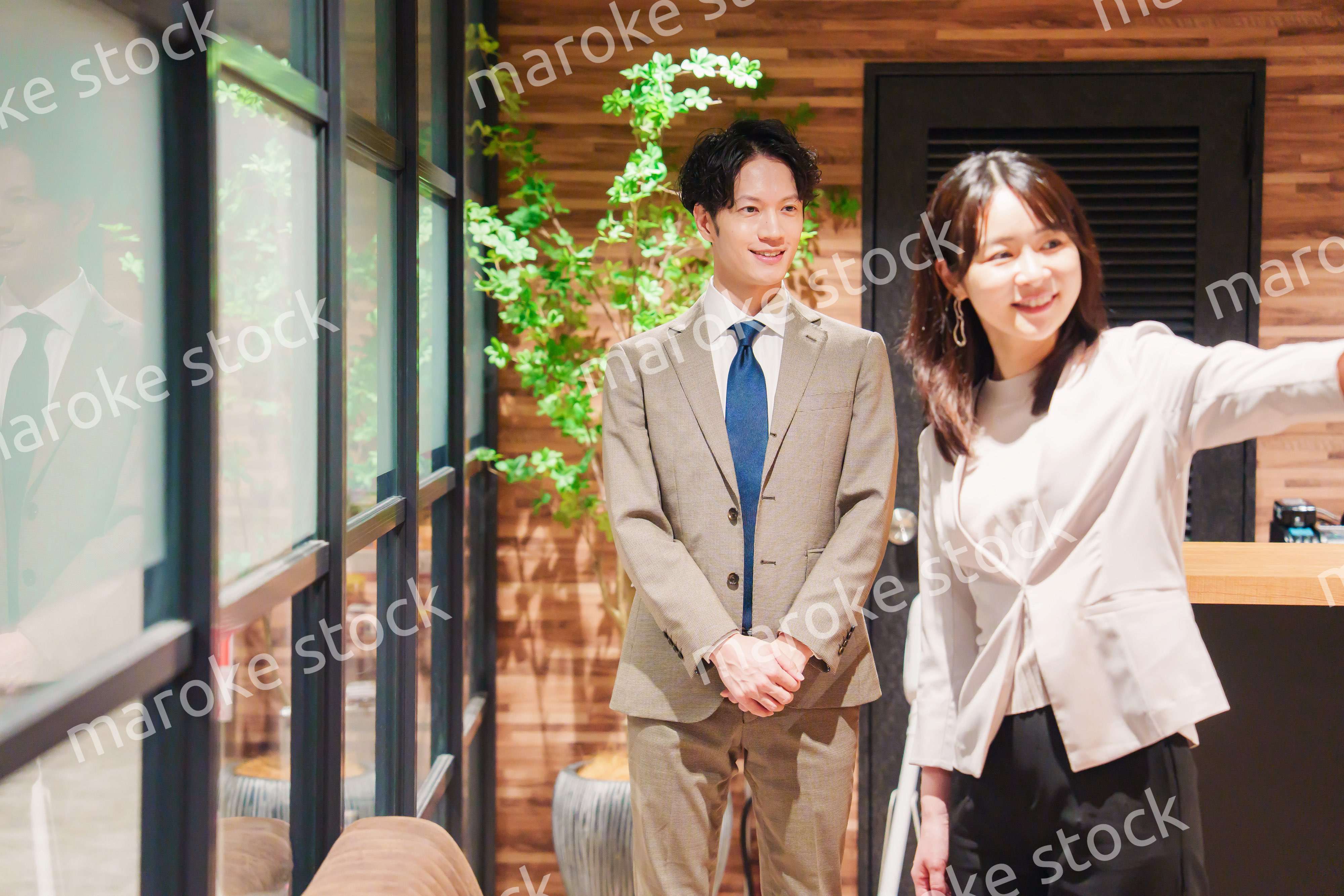 オフィスにお客様を通す女性の秘書