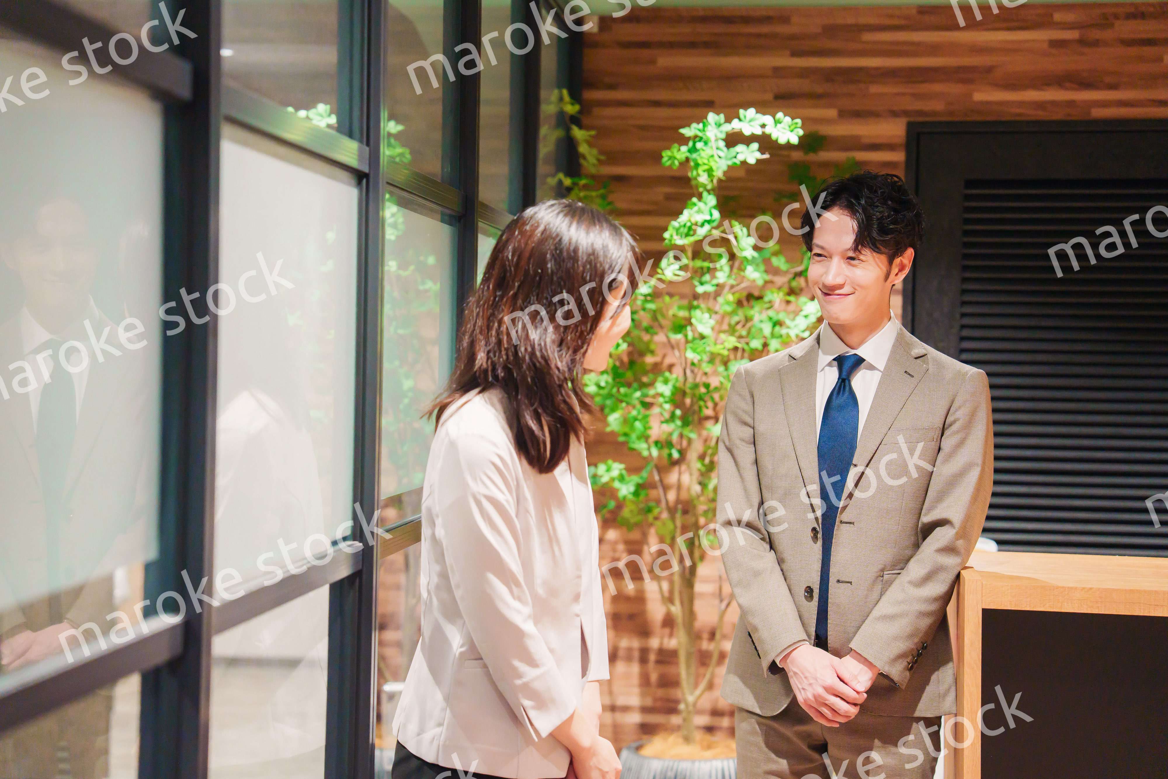 オフィスにお客様を通す女性の秘書